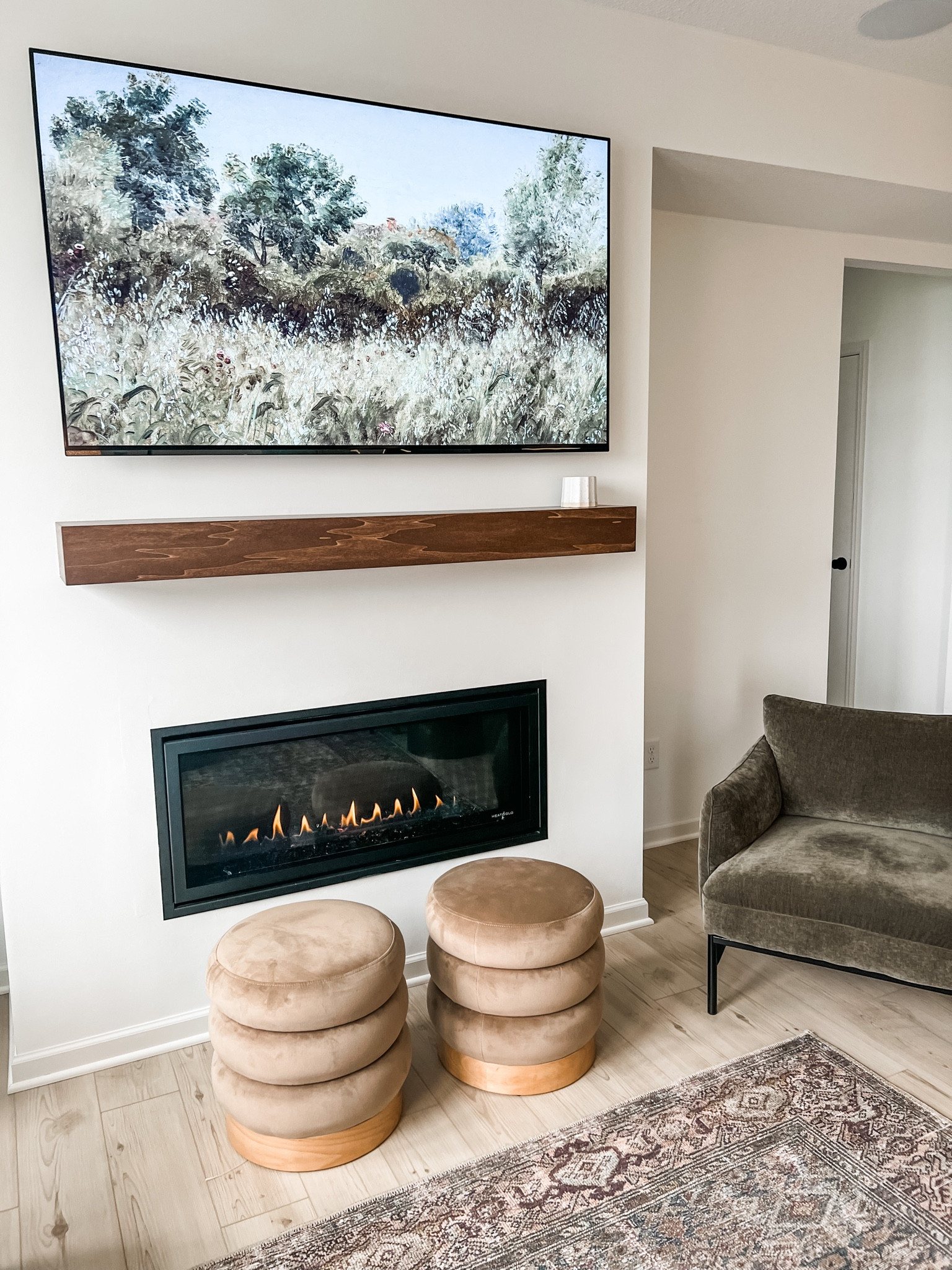 Picture frame TV art. Etsy, studio McGee furniture, west elm Penn chairs, velvet ottomans poufs, green accent chair, spring summer decor and art. Living room furniture, oriental moody modern rug, mantle. 