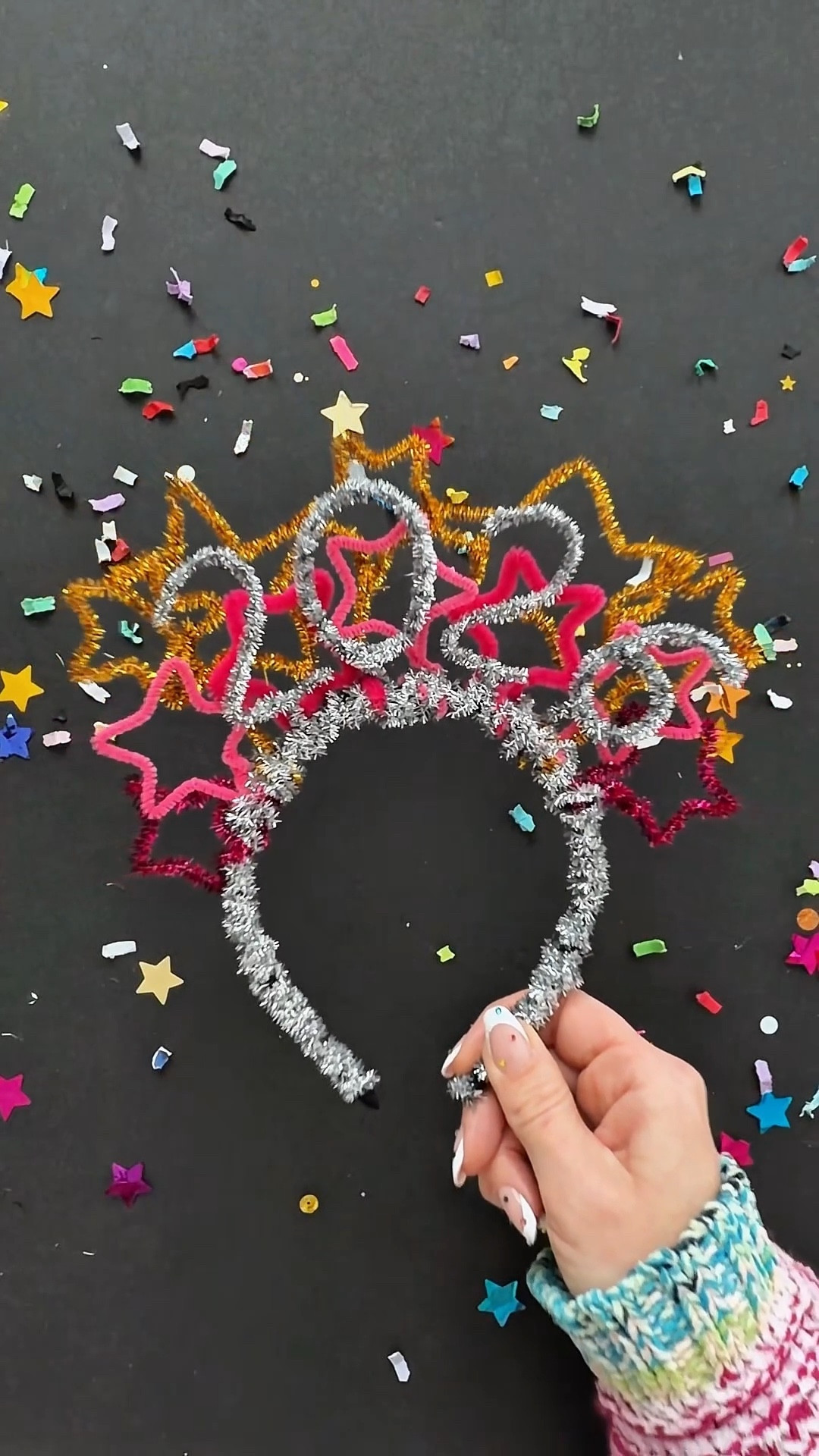 

DIY Pipe Cleaner Crown 🌟 Easy NYE craft

This simple DIY NYE crown has had millions 🤯 of views over the years, and so many of you made your own. I can’t wait to see what you all create this year 🥳🤩

Make it as simple or elaborate as you want. All you need are pipe cleaners and a headband ⤵️

⭐️ Make a handful of pipe cleaner stars. Mom hack: wrap a pipe cleaner around a star cookie cutter. Leave a little extra on the end to wrap around your headband.

I made the 2️⃣0️⃣2️⃣6️⃣ numbers by folding my pipe cleaner over itself to make the numbers bolder. Use the extra to secure it to the headband. I kept layering stars until I thought it looked ✨just right✨.

To finish, wrap pipe cleaners around the entire headband. Overlap the spots where you attached the stars to cover and secure the ends.

My kids thought it was most comfortable to leave about one inch bare on each side so their ears weren’t irritated by the pipe cleaner.

✨ Ta-Da 🥳🎉

#newyearscraft #craftsforkids #newyearsdiy #momhack #newyearseve, nye, New Year’s Eve 2026, easy diy, new year crafts for kids, new year celebration, happy new year, happy New Year’s Eve , party ideas, kids crafts, kids activities 

#LTKKids #LTKmomlife #LTKHoliday