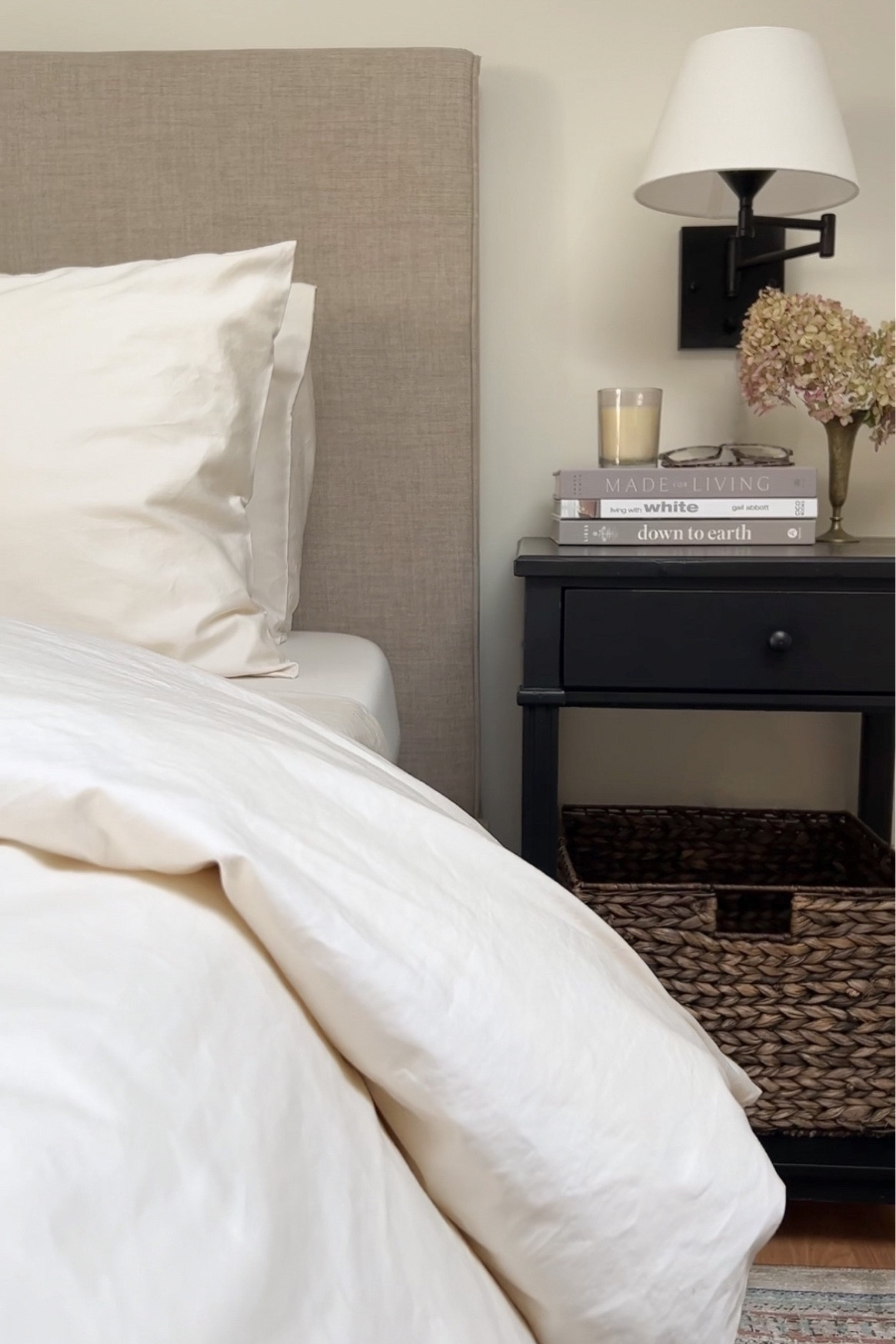 Our primary bedroom & favourite sheet set

Upholstered headboard, wall sconce, storage baskets, coffee table books, black nightstand, area rug