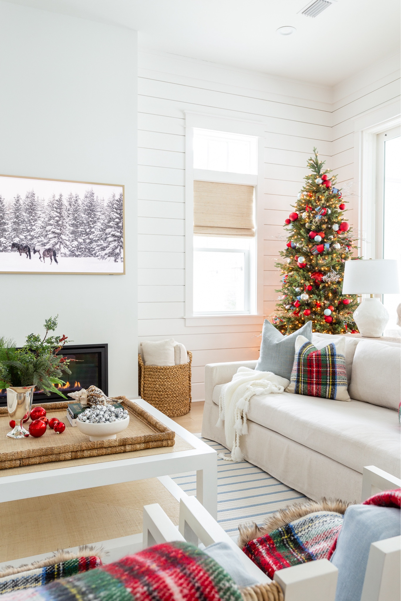 Our cozy coastal Christmas living room with linen sofas, blue and white striped rug, red Stewart plaid throw pillows, a 9' Christmas tree with red and silver ornaments, evergreen stems in a silver trophy vase, a raffia coffee table and cozy throw blankets. #ltkholiday #ltkhome #ltksalealert #ltkfindsunder50 #ltkfindsunder100 #ltkstyletip #ltkseasonal 

#LTKHoliday #LTKSaleAlert #LTKHome