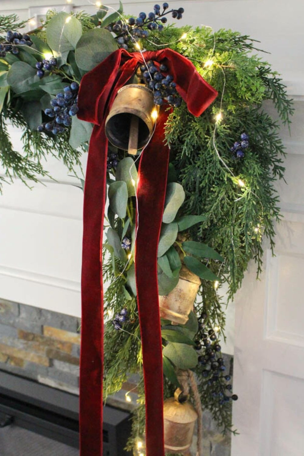 Cedar garland with eucalyptus garland on my fireplace mantel. String lights. Velvet burgundy red ribbon. Blueberry picks. Gold bead bells. 

#LTKHoliday #LTKSeasonal #LTKHome