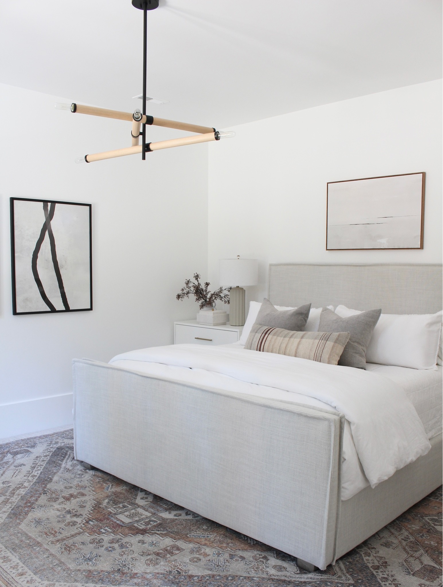 Guest bedroom progress! Chandelier, rug, upholstered bed, wall art, nightstands, pillows.

#LTKhome