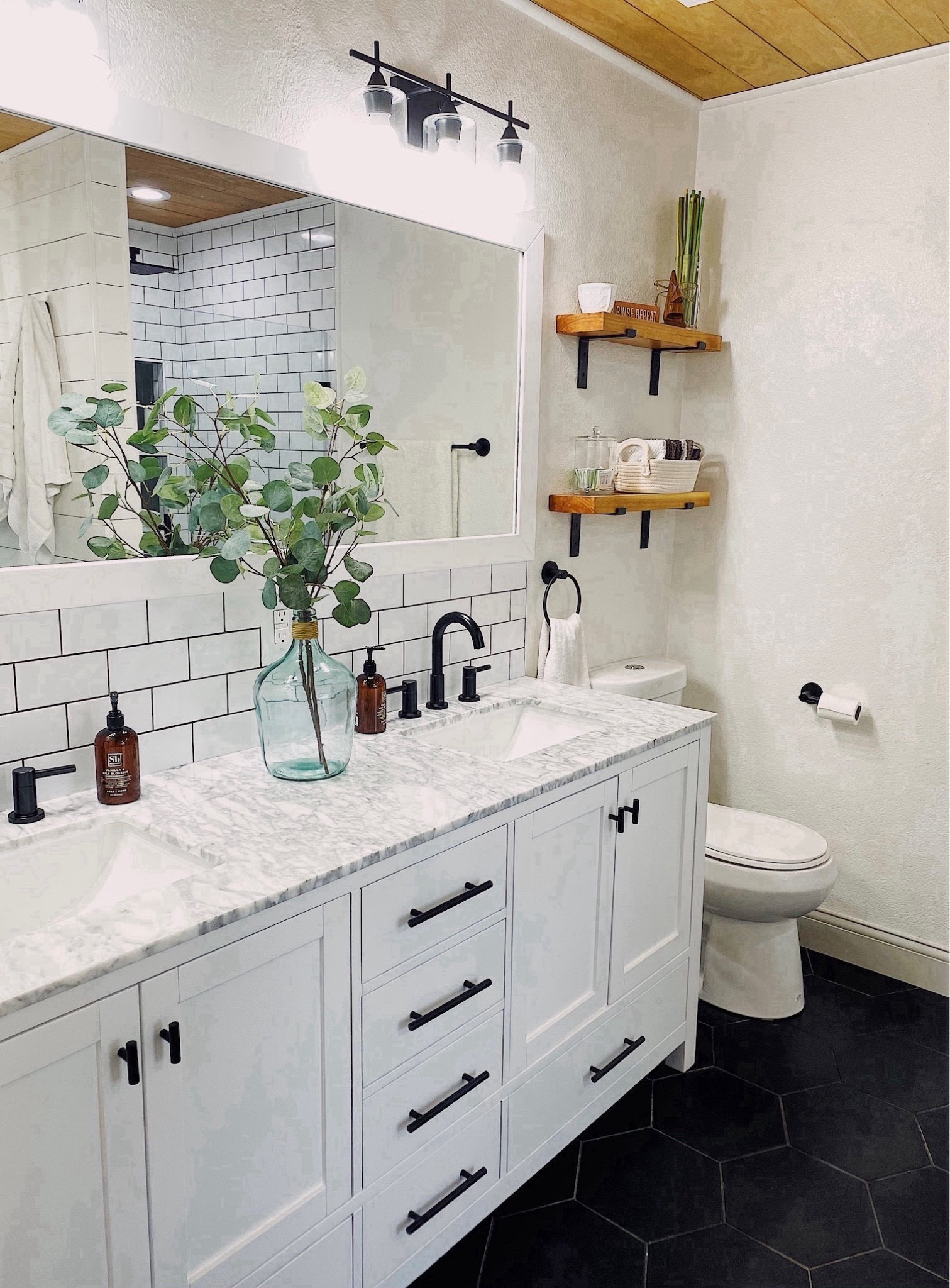 Bathroom styling. 

Home decor, home finds, bathroom decor, white vanity with mirror, black drawer handles, black brackets, lighting, black vanity lights, clear jar, farmhouse bathroom, eucalyptus stems, large glass jug decor, black bathroom faucet, glasses holder, best hand soap ever, white bathroom#LTKBacktoSchool 

#LTKHome #LTKFindsUnder100 #LTKSaleAlert
