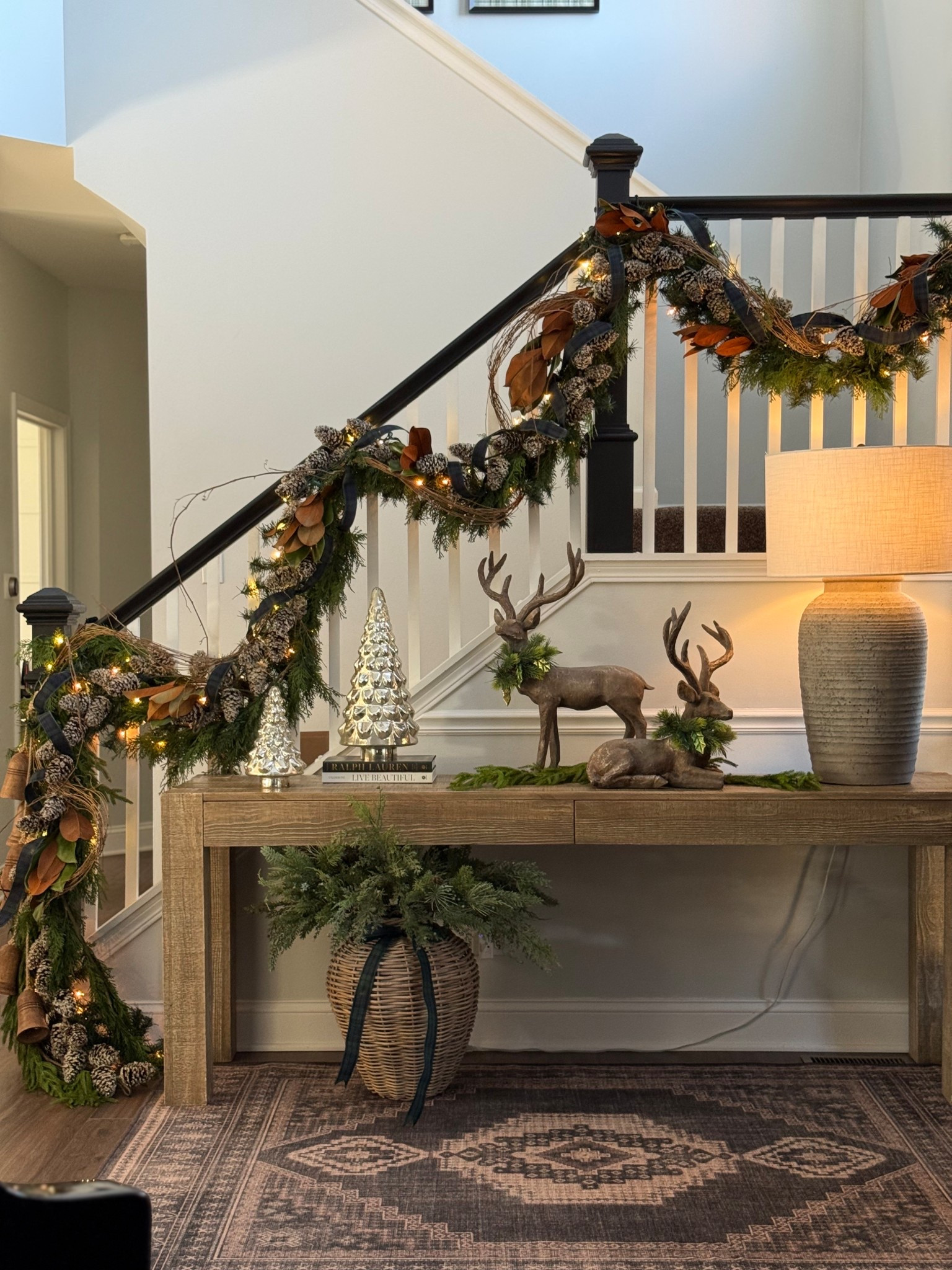 Console styled for Christmas 2025! I went simple here with a few mercury, glass Christmas trees, a couple of books and some deer so that I can let the garland on the railing have a moment.

#LTKHoliday #LTKSaleAlert #LTKHome