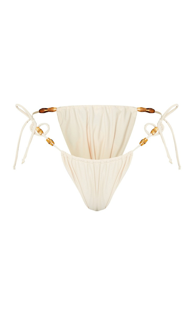 Sand Wooden Bead Ruched Tanga Tie Side Bikini Bottoms | PrettyLittleThing US