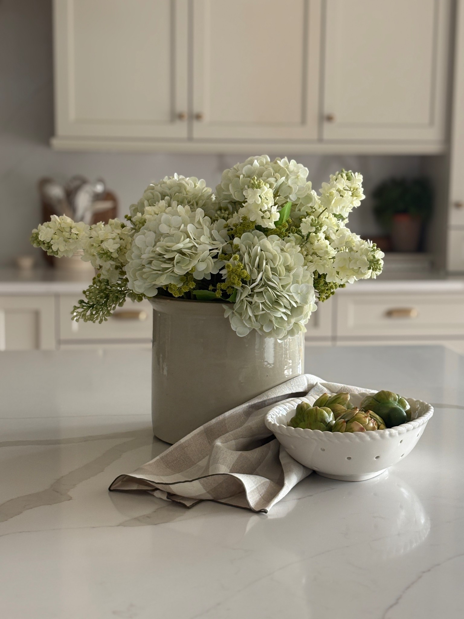 The easiest way to make your kitchen feel designer? ✨
Add one oversized statement arrangement on your island.

These soft white hydrangeas instantly make the space feel layered, lived-in, and elevated — without cluttering your counters. I always say: go bigger than you think and keep the palette neutral for that high-end, collected look.

Linked the vase, similar faux stems, bowl, and a few of my favorite neutral kitchen styling pieces 🤍

Would you style your island with florals year-round or just seasonally? 🌿

#kitchenstyling #neutralhome #islanddecor #organicmodern #collectedhome #ltkhome #homesofltk #houseofsaintdesign 

 

#LTKHome