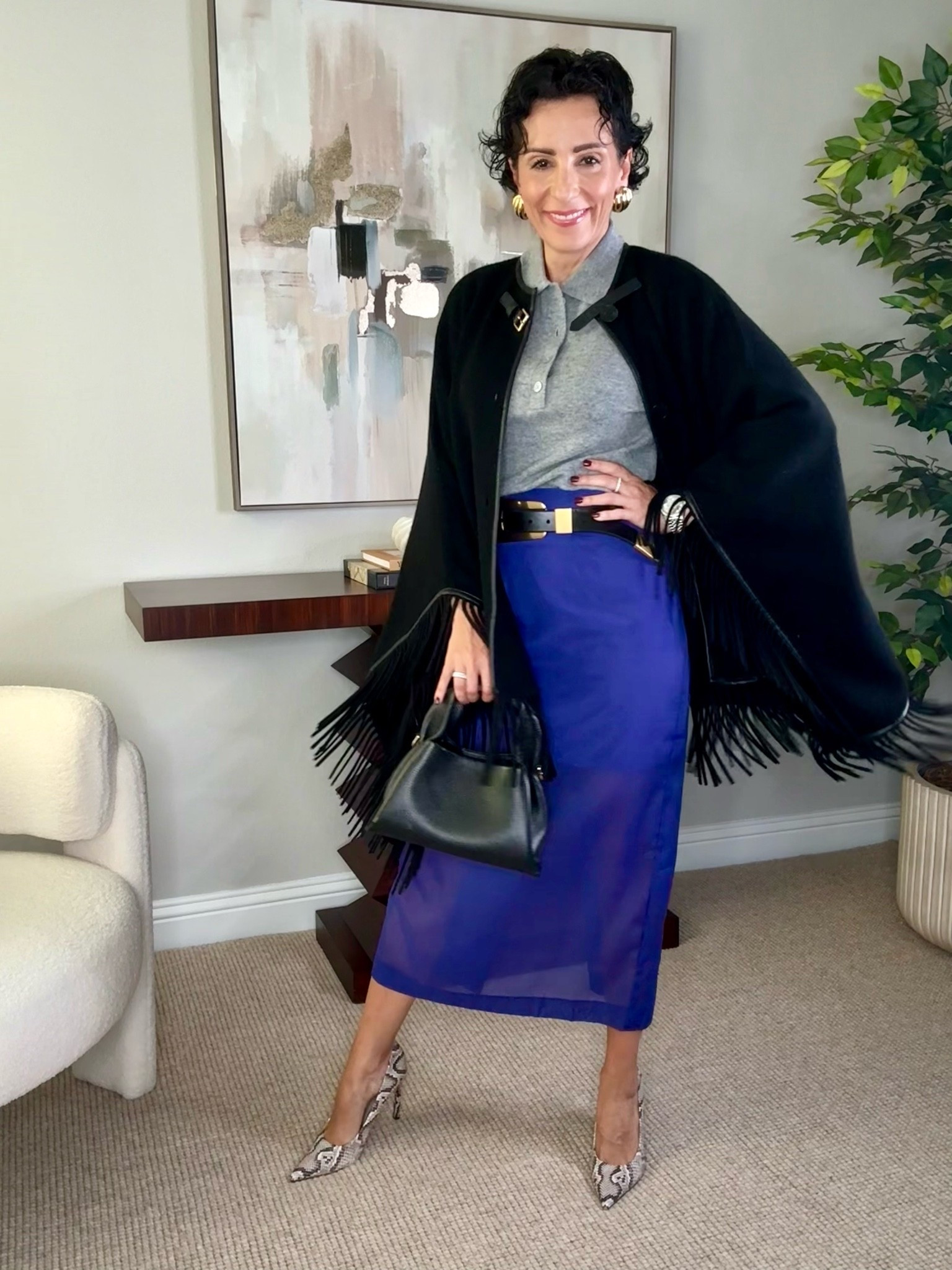 This is how I love to mix classic pieces with a little personality. The gray collared knit keeps the look polished, while the cobalt blue skirt brings in a beautiful pop of color. The black fringe cape adds movement, and the snakeskin heels are an unexpected finishing touch. A great example of how texture and color can make an outfit feel special without overdoing it.
cobalt blue skirt, fringe cape, gray knit top, fall outfit ideas, statement skirt, snakeskin heels, women over 50 style, elevated fall style, colorful fall outfit, sophisticated style, fall layering, stylewitheugenia