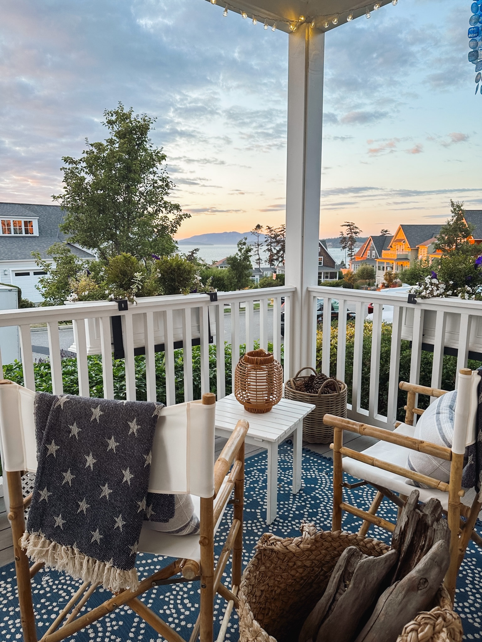Summer porch: Folding bamboo director’s chairs, navy blue star throw blankets, blue and white outdoor rug, white string lights, railing planter boxes 

#LTKSeasonal #LTKstyletip #LTKhome