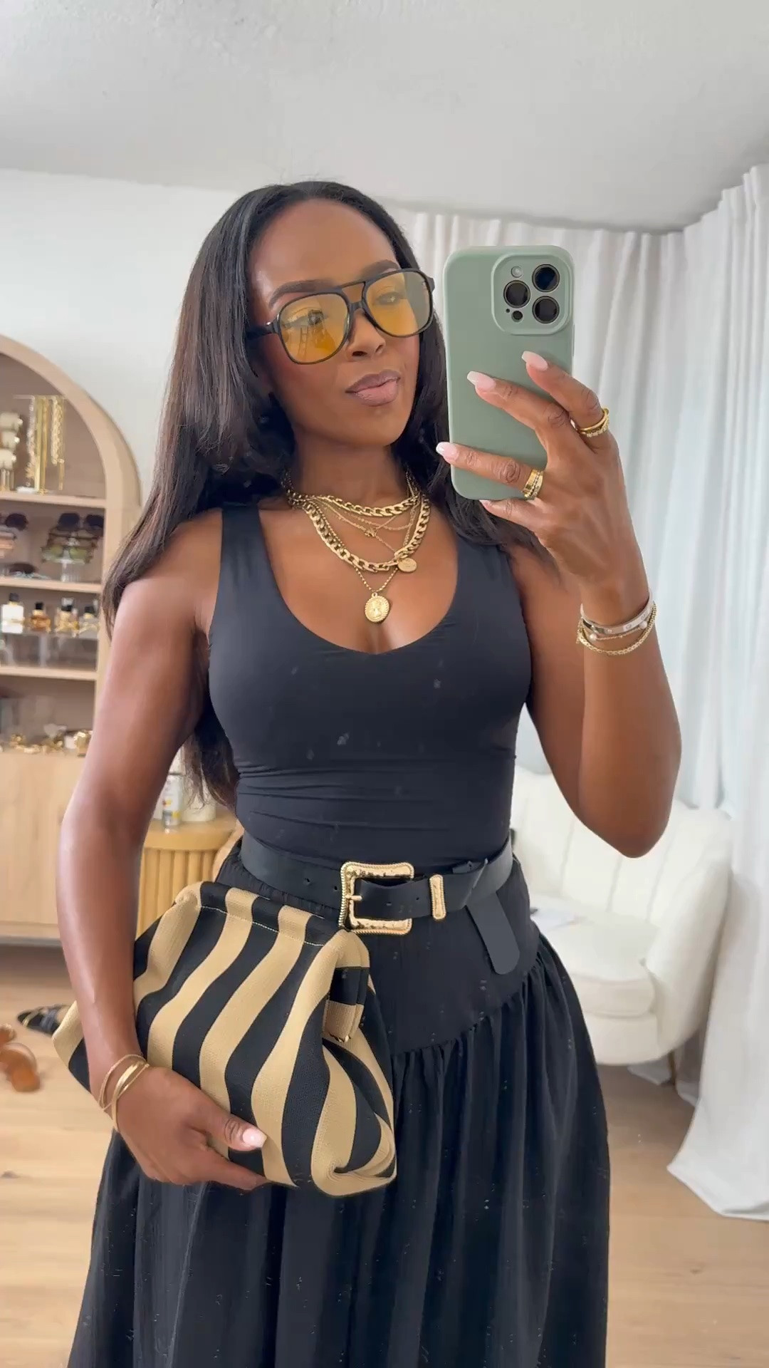 Hi Babes!

This look is proof that an all-black outfit never fails. The fitted tank paired with this dramatic flowy maxi skirt creates the most beautiful silhouette, and the statement belt adds just the right amount of structure. I love how the striped clutch breaks up the monochromatic look while still keeping everything elevated and chic.

If you're petite and curvy, this outfit is incredibly flattering because the fitted top highlights your waist while the volume of the skirt creates gorgeous balance. The high-waisted skirt elongates the legs and gives that effortless luxury aesthetic that's always in style.

Where to wear this:
• Dinner dates
• Summer vacations
• Resort dinners
• Girls' night out
• Wine tastings
• Brunch with friends
• Special occasions

Undergarments: Nude seamless bra and seamless brief for the smoothest fit.

Everything is linked below.

xx Kira | IG: KirasFashionFinds

34D - 27 - 40 • Size Small or 4

Follow me on Instagram and YouTube @kirasfashionfinds