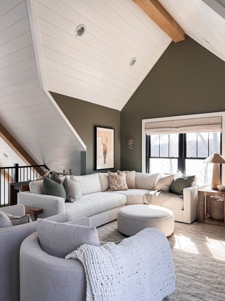 Cozy loft lounge space! We love the sectional sofa so ultimate lounging and the large round ottoman is perfect to throw your feet up on! 

Pottery barn, area rug, swivel chairs, throw pillows, framed wall art, wall sconce, rustic wood end table, 

#LTKhome #LTKstyletip
