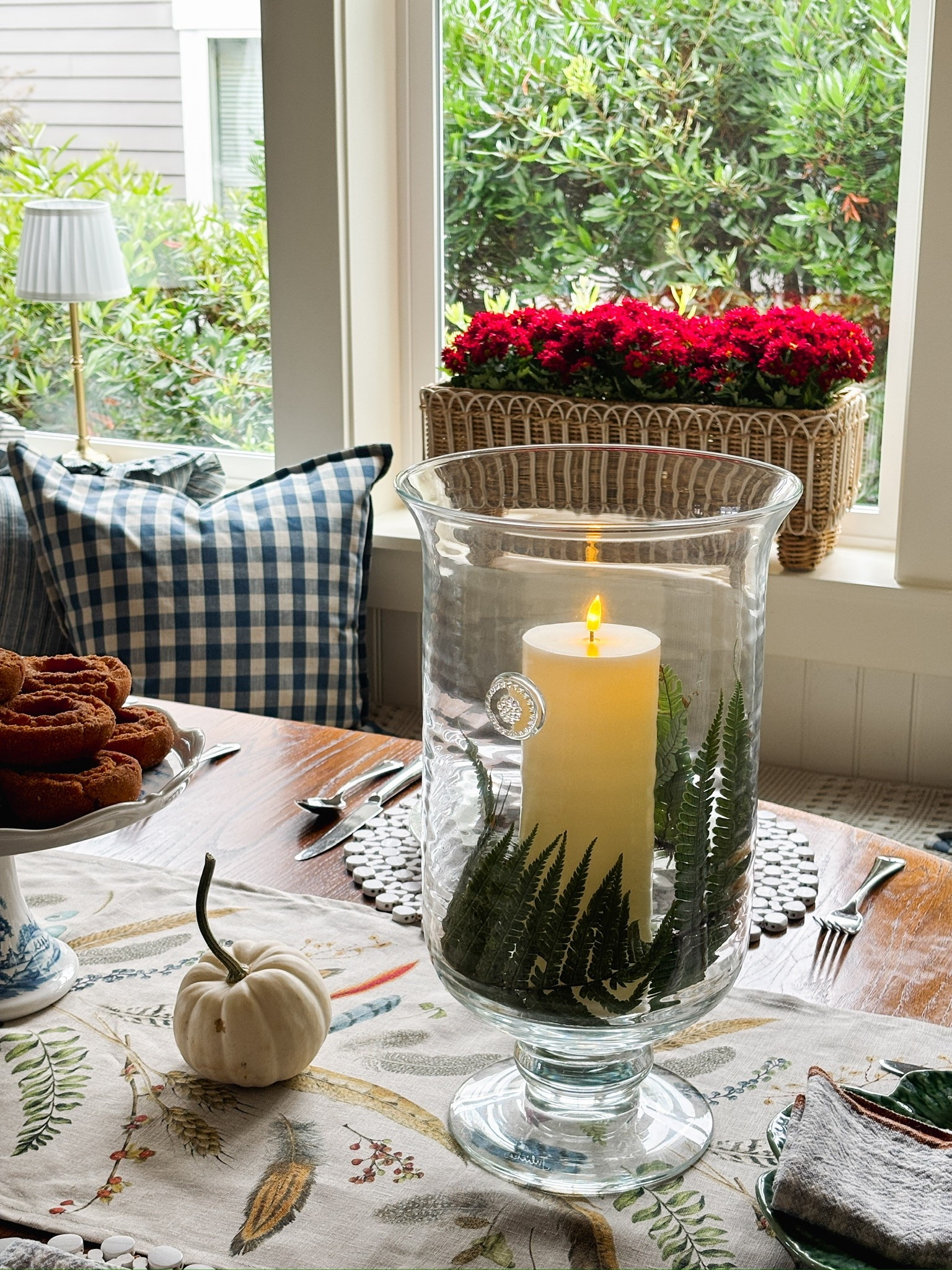 Glass hurricane, rattan planter, woodland table runner, gingham pillow