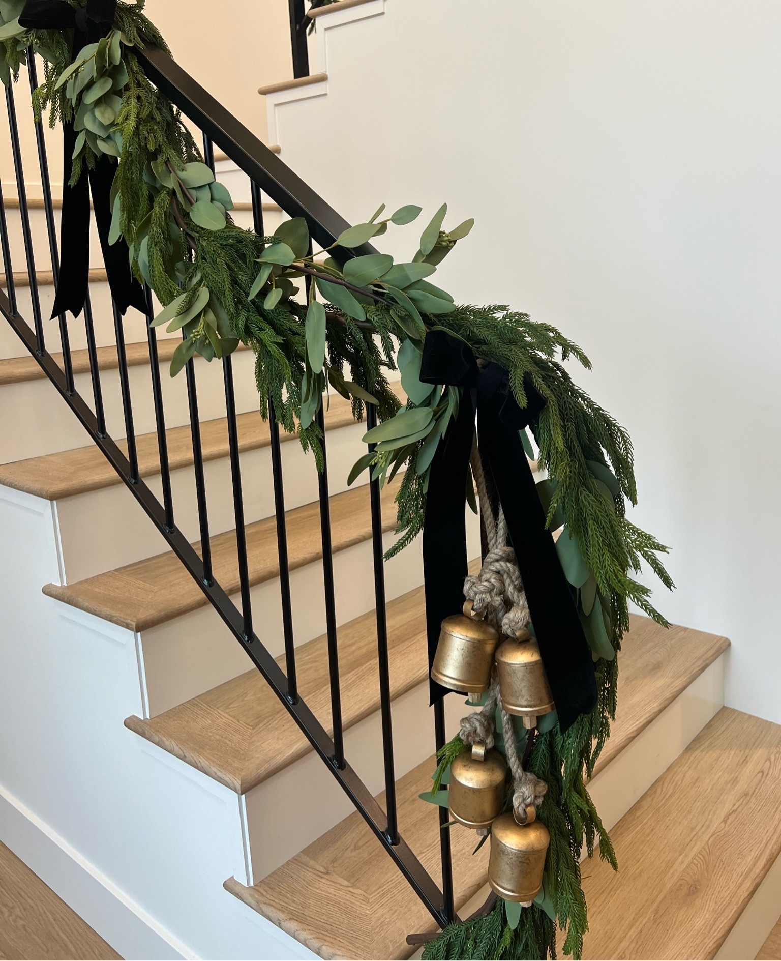 Holiday staircase! 🎄🎅🏼

Garland is layered with cypress and eucalyptus garland from walmart! Added bells & velvet bows!

Everything was attached using a Velcro roll!

Flooring is from Hewn Flooring - color: Honey