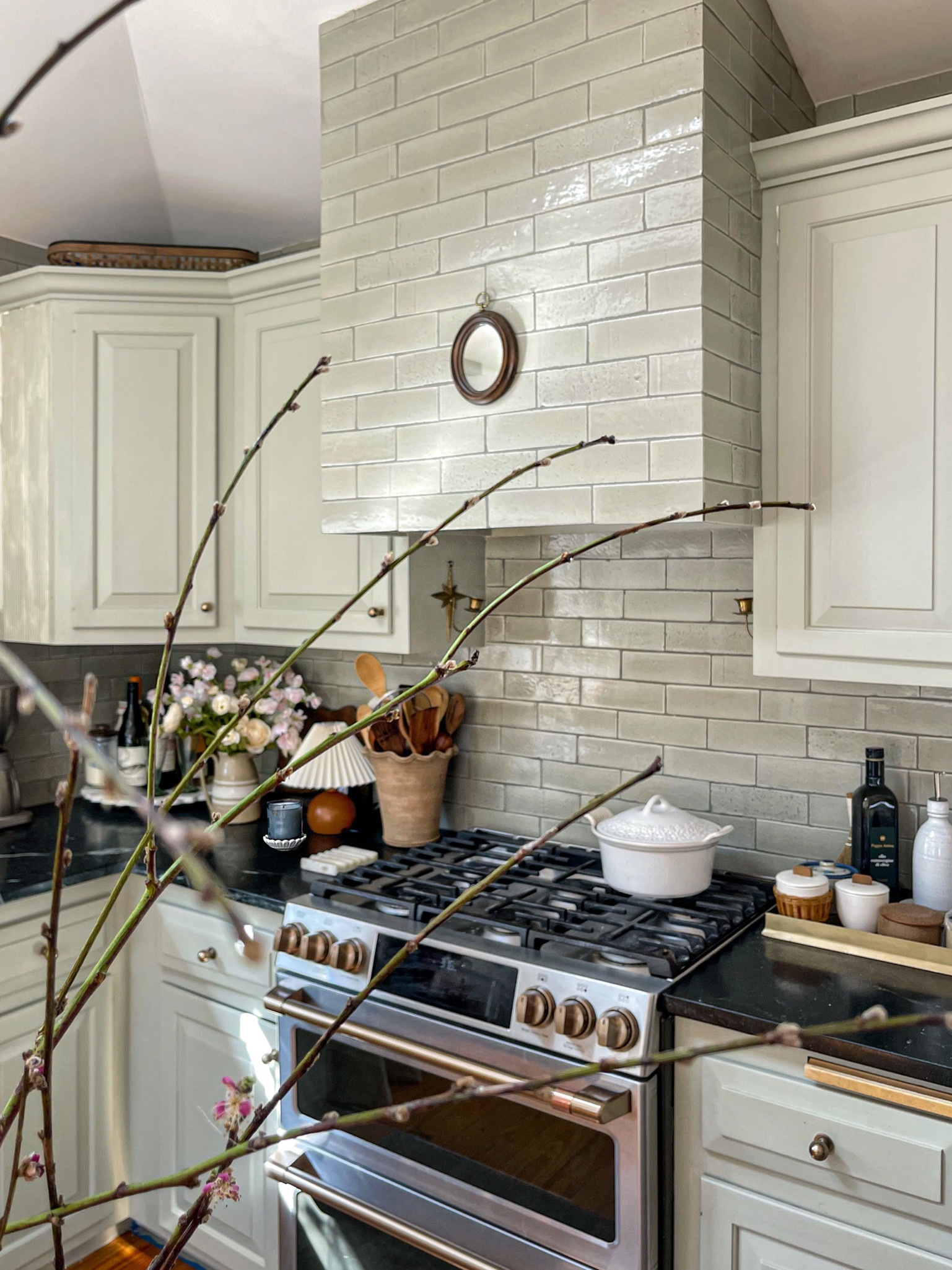 I have never regretted, nor will I ever regret, doing a custom tiled range hood. After leaving my beloved herringbone backsplash behind when we moved, and feeling not so into these old cabinets (admittedly made better once I painted them), I knew that the @fireclaytile handmade brick needed to be the star of this kitchen. Featuring it front and center on the hood was the way to do that and I 🤍 it so much. #farmhousedialfano #mstarrdesign

PS. how pretty does that little vintage mirror look on it?! 

PPS. color is Elk. 

#LTKhome #LTKFind