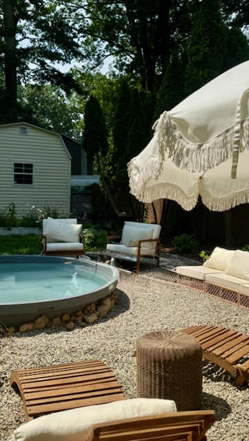 DIY stock tank pool on a gravel patio with a fringe umbrella and lounge chairs. Budget friendly backyard pool setup perfect for summer hosting. 

 #LTKSeasonal #LTKHome