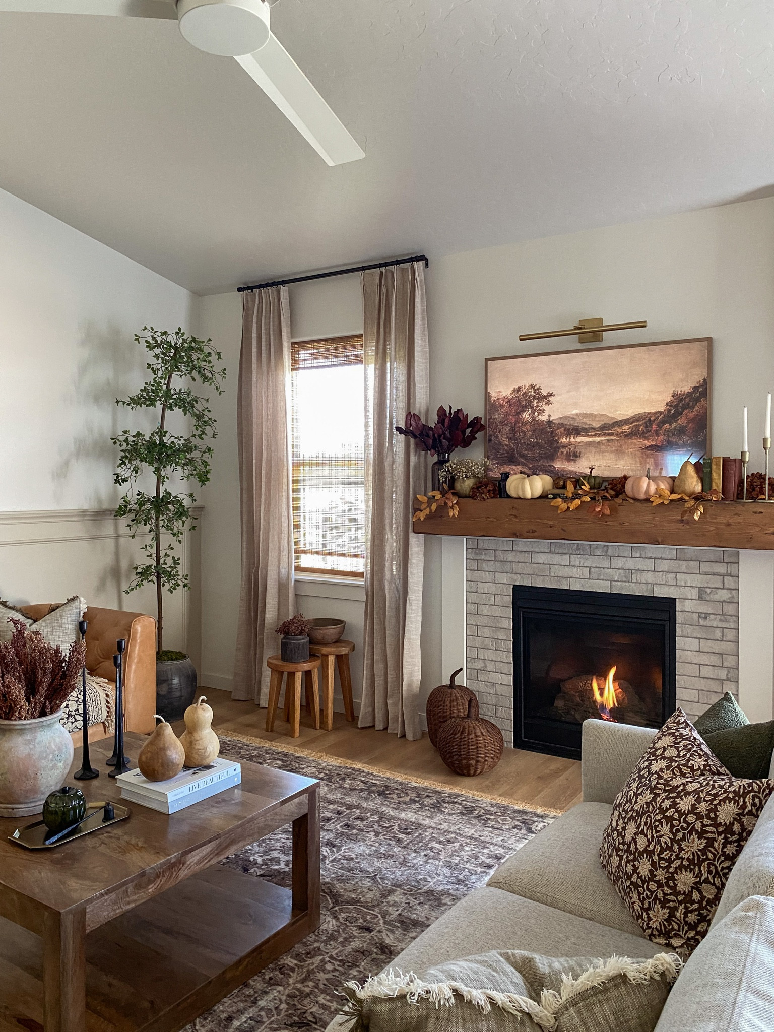 Fall decor, Living room inspo, custom curtains, pinch pleat curtains, floor to ceiling curtains, neutral sofa, beige sofa, west elm penn chair, green accent chair, vintage pillows, Turkish pillows, boucle pillow, shady lady tree, faux tree, greenery, Walmart floor lamp, rattan floor lamp, round coffee table, wall sconce, tapered candle holder, leather sofa, shady lady tree, loloi Sinclair rug, throw pillows, floor length mirror, arch mirror, Target home decor, affordable home, black cabinet, studio McGee cabinet, round glass coffee table, target accent table, Sinclair loloi rug, vintage inspired rug, vintage milking stool, foot stool

#LTKSeasonal #LTKfindsunder100 #LTKhome