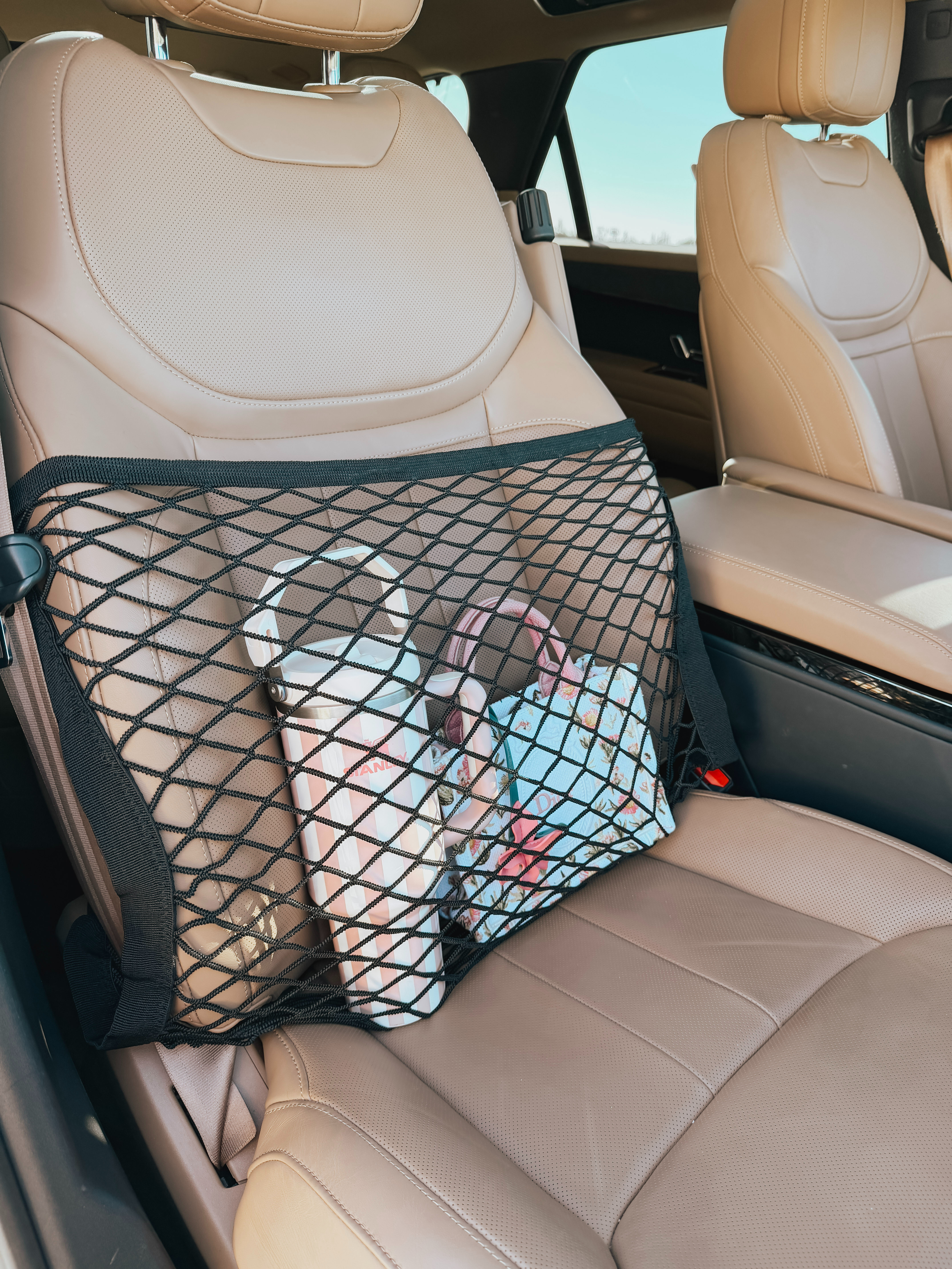 A car front seat organizer mesh net is needed because it helps keep the vehicle interior clean, organized, and safer while driving. Loose items like phones, purses, water bottles, snacks, chargers, and tissues often slide around the cabin, fall onto the floor, or get stuck between seats during braking or turns. A mesh net organizer creates a dedicated storage area that keeps these essentials secure and within easy reach. 

 #LTKdayinmylife #LTKmomlife
