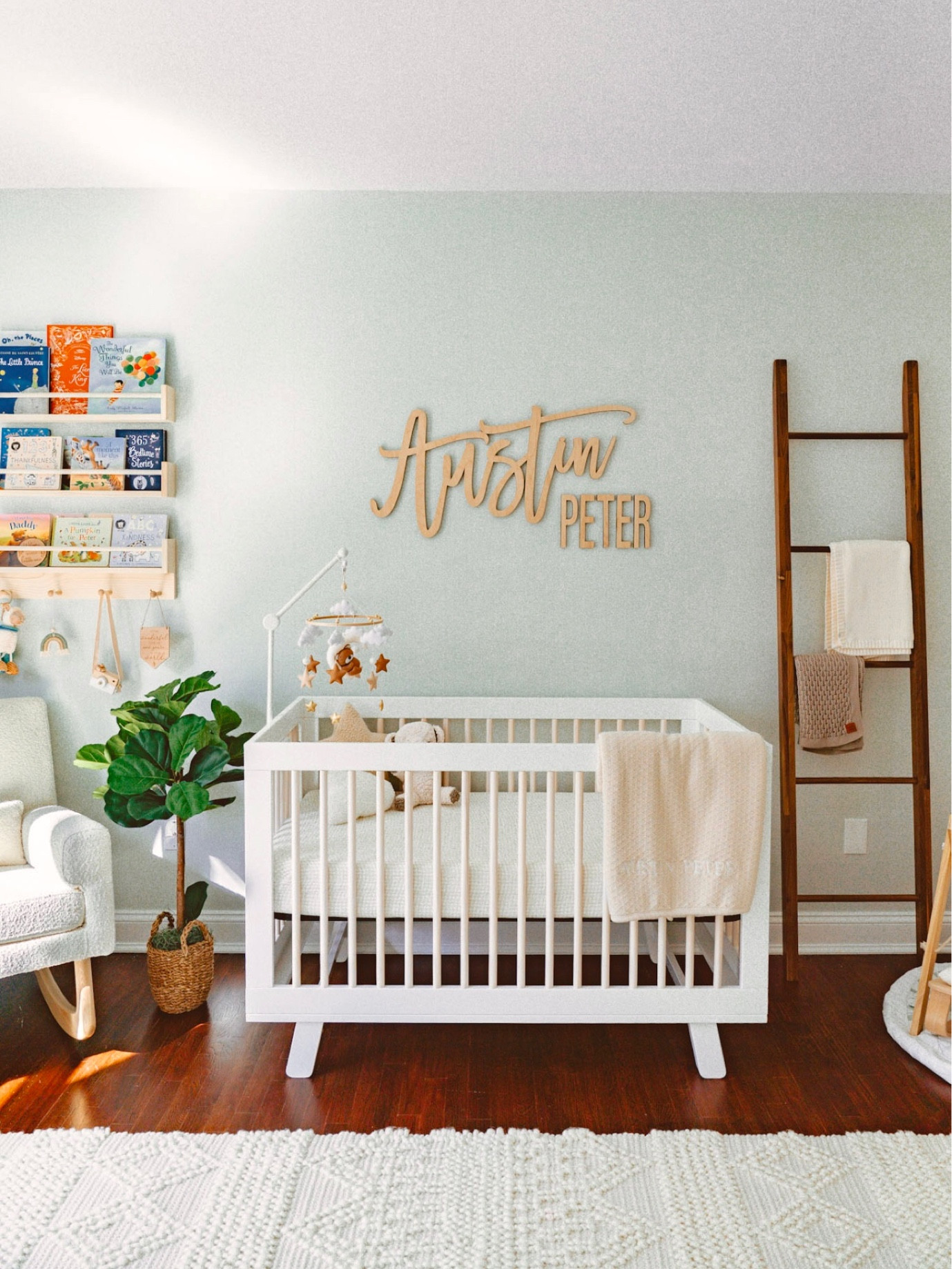 Accent wall in my baby boy’s neutral nursery! Babyletto Hudson Crib with custom baby name sign and bear baby mobile from Etsy. Boucle rocking chair with wooden book shelves above and a faux floor plant to add a little greenery. Nursery blanket ladder. My favorite handmade wool rug and matte black with wooden beads ceiling light for final touches. 

Neutral nursery design. Boy kids neutral nursery decor. Baby boy’s room decor  

#LTKbaby #LTKfamily #LTKkids