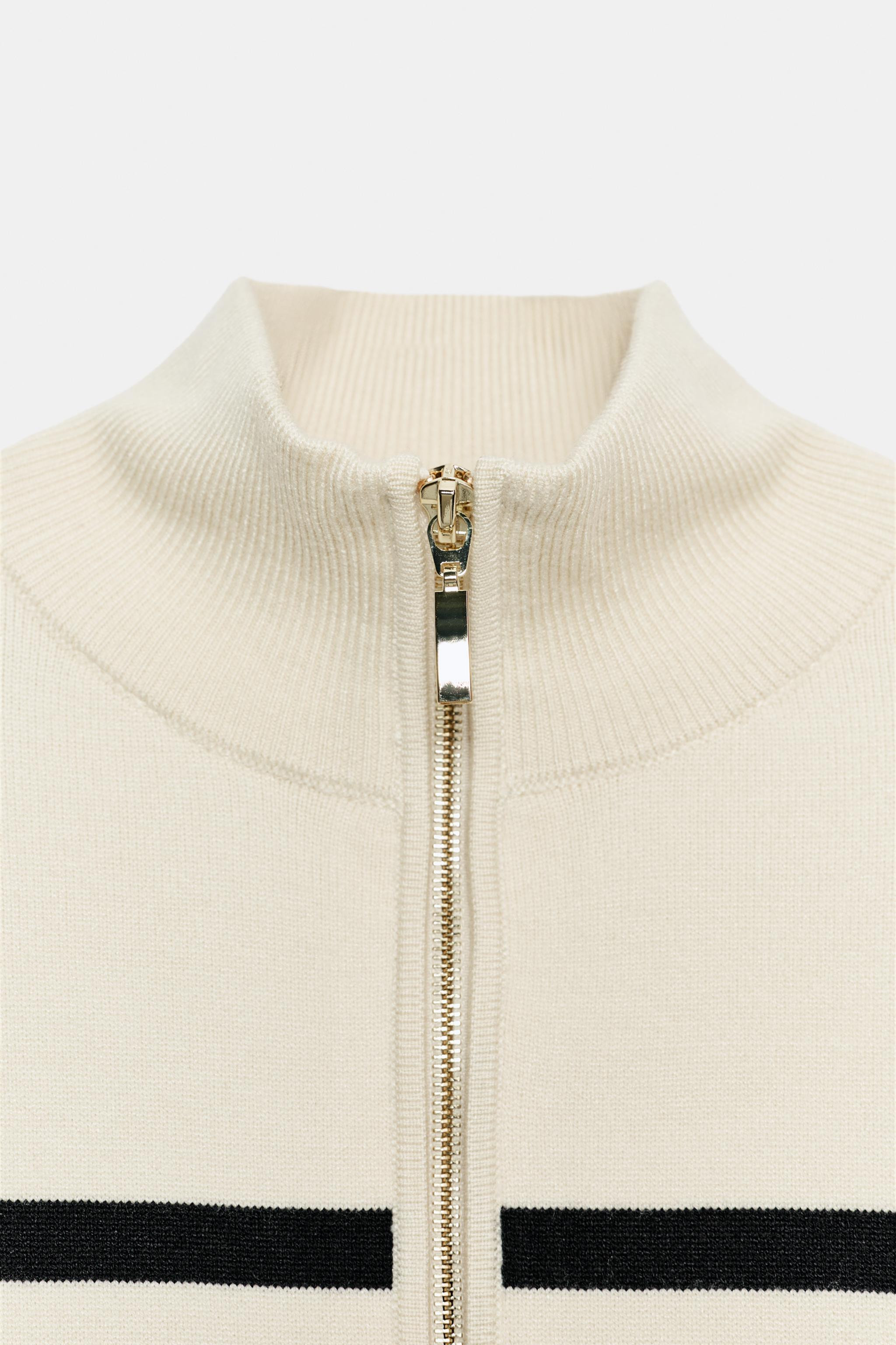 Model height: 177 cmJumper with a high neck and long sleeves. Front zip fastening with metallic d... | Zara UK