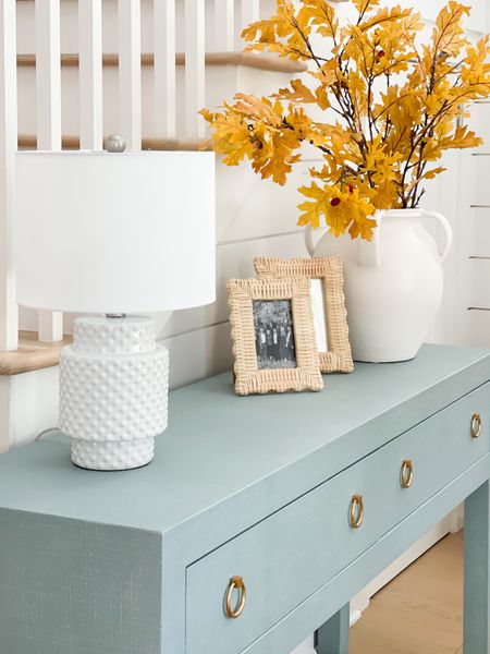 Our fall entryway with our blue linen console table, hobnail lamp (designer look for less), scalloped wicker frames, and a white ceramic vase filled with golden oak leaves. Loving the blue and yellow color combo for fall!
.
#ltkhome #ltkseasonal #ltkfindsunder50 #ltkfindsunder100 #ltkstyletip #ltkover40 #ltksalealert

#LTKhome #LTKSeasonal #LTKsalealert