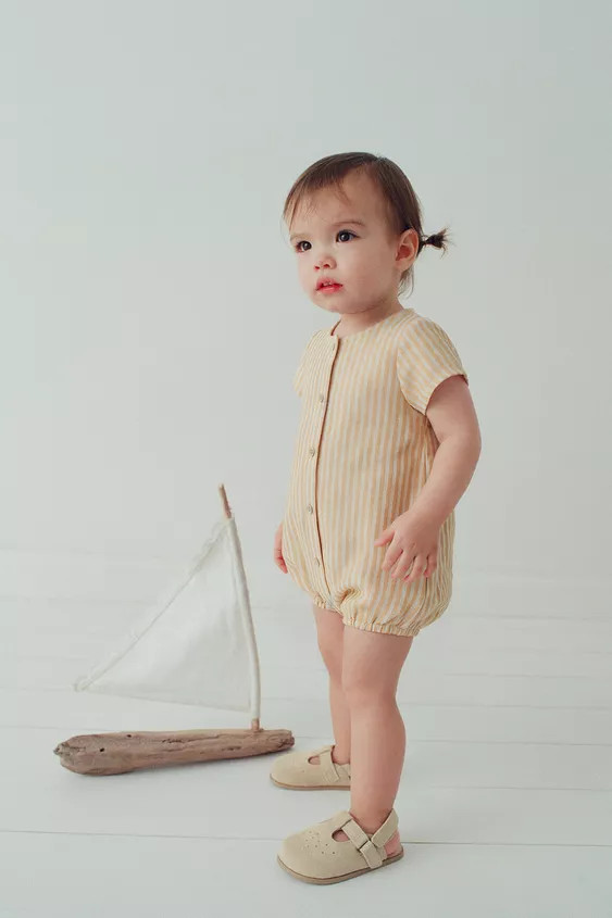 Round neck romper with short sleeves. Featuring a button-up front, elasticated hem and a striped ... | Zara UK