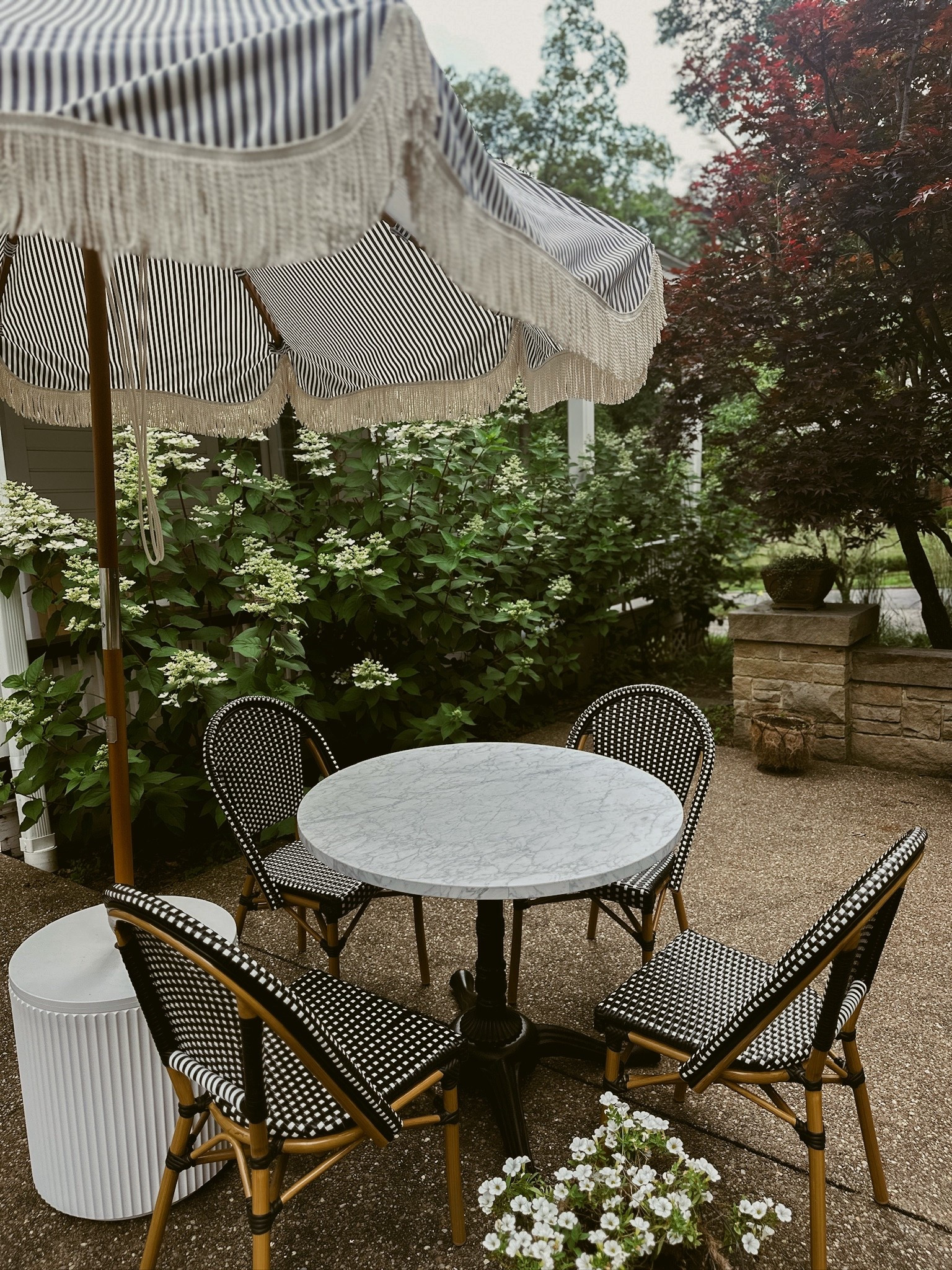 Outdoor French Bistro striped umbrella marble bistro table black and white wicker chairs umbrella holder 

#LTKHome #LTKSeasonal #LTKFamily