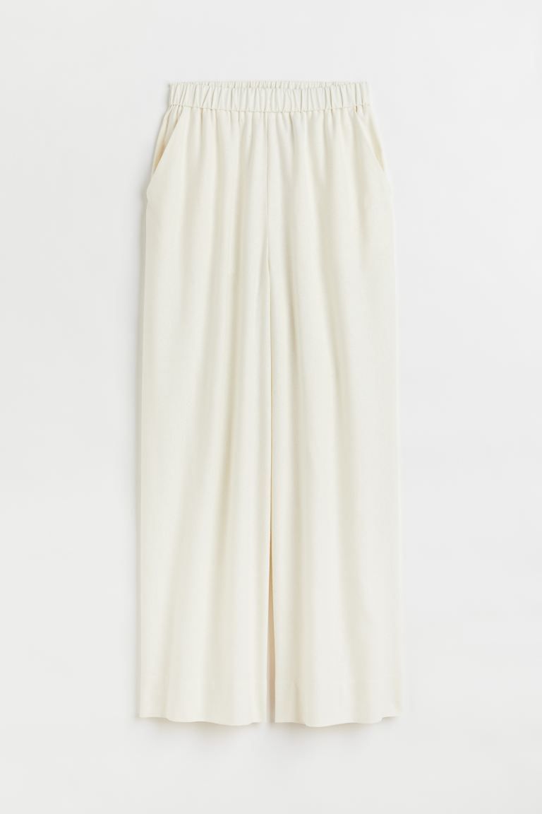 Trousers in textured silk. Regular waist with covered elastication, diagonal side pockets and wid... | H&M (US)