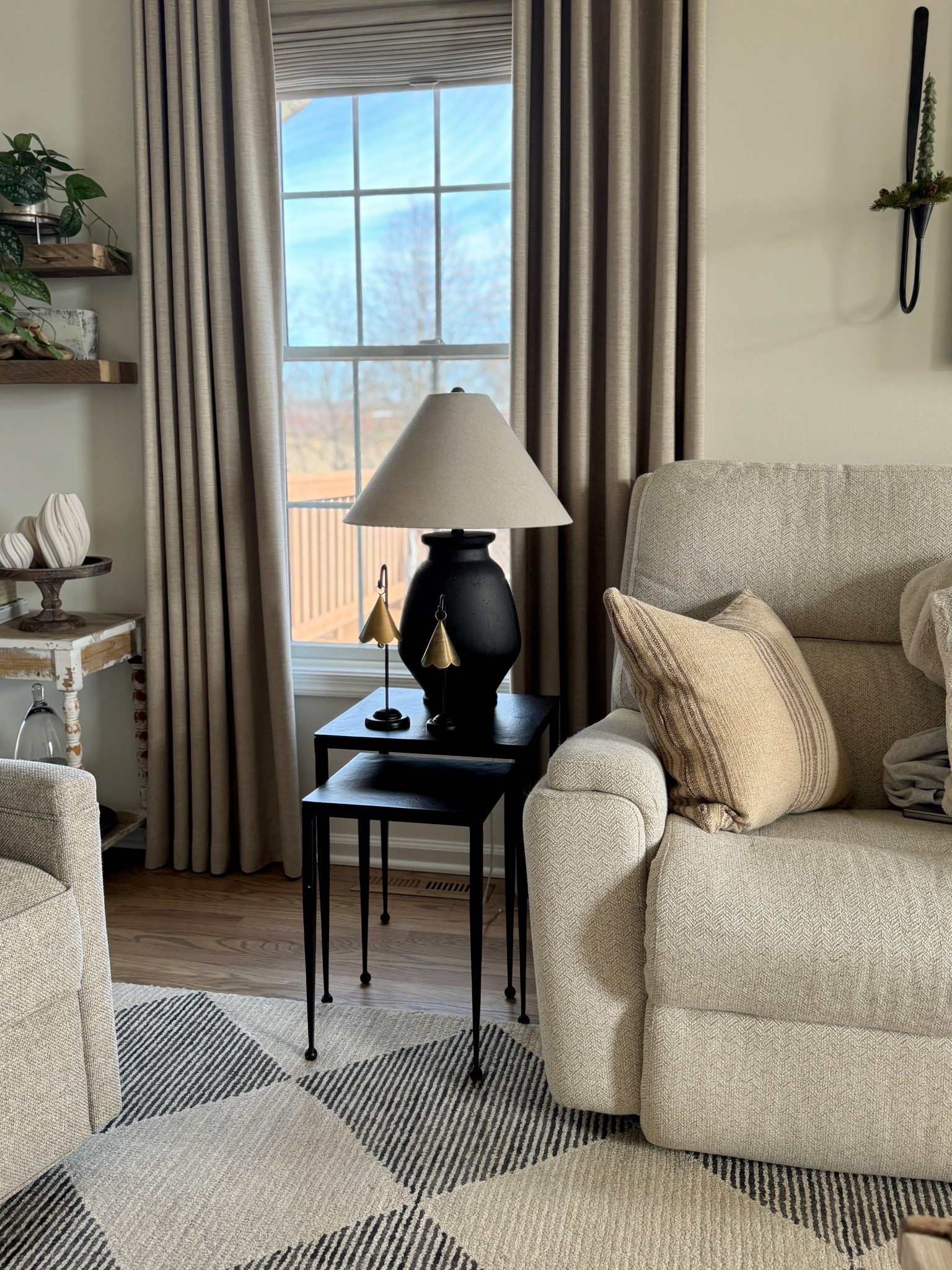 Love my new black nesting tables, brass decorative bells, reclaimed hardwood shelves, wall candle sconces, pillow cover, area rug, similar lamps 