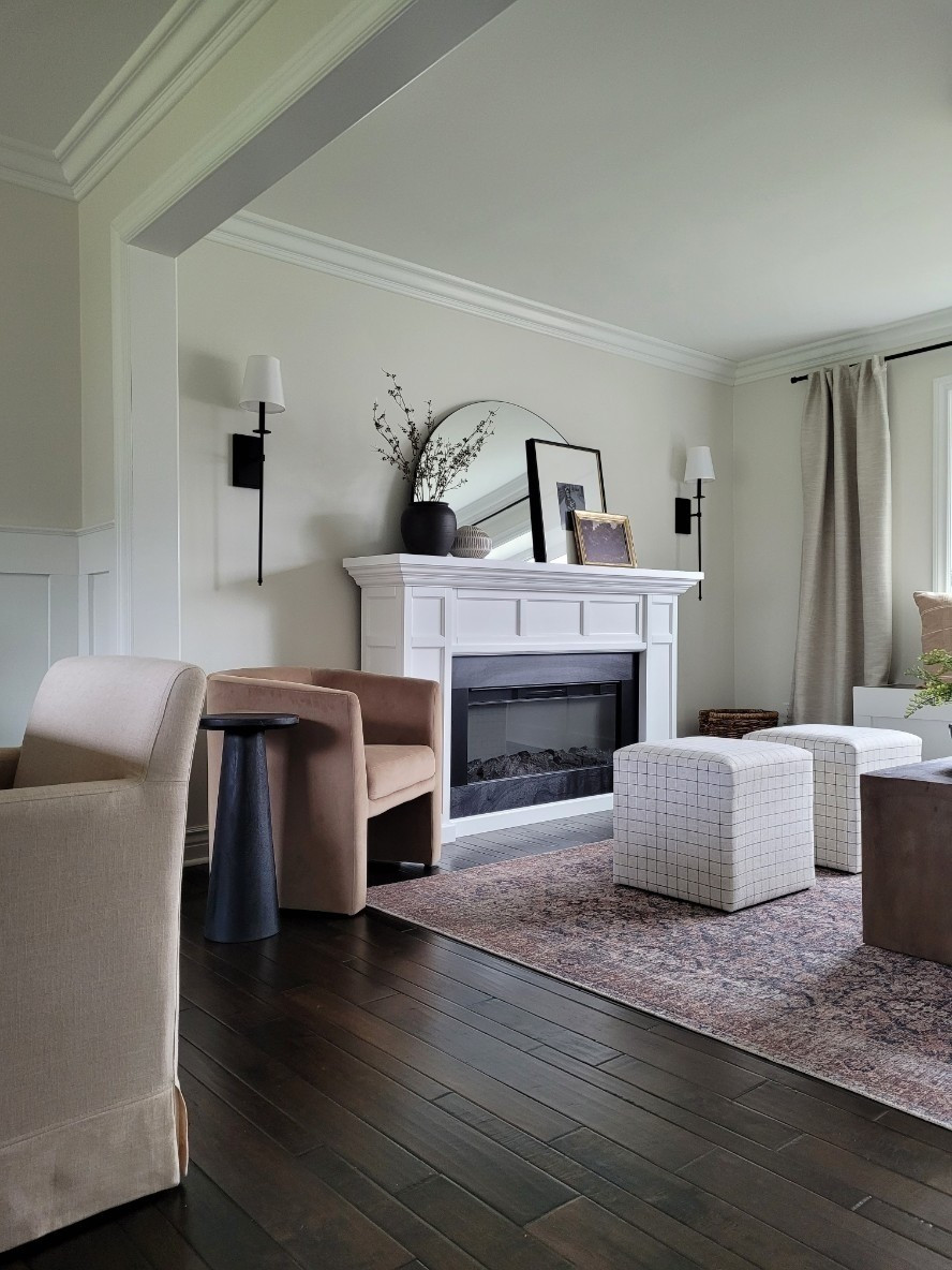 Simple clean living room aesthetic with this freestanding electric fireplace,  barrel chair,  upholstered cube ottomans on one side of my small coffee table,  vintage inspired rug,  and half moon arch mirror! I added oversized sconces on either side of the fireplace and love how cozy it makes this room feel! Amazon home finds

#LTKHome #LTKFindsUnder100 #LTKStyleTip