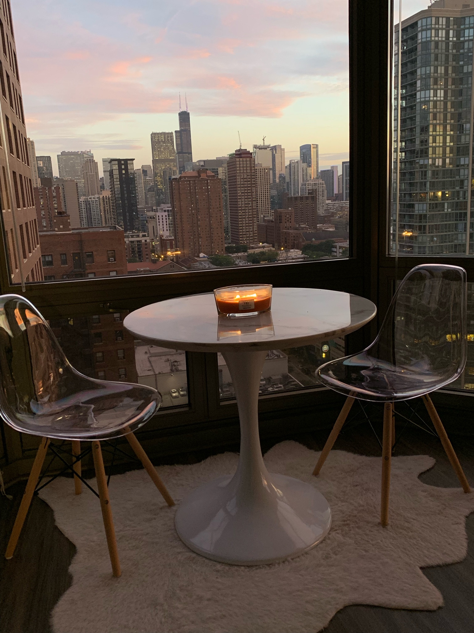 chicago city apartment white marble round dining table, beige cowhide rug, clear dining chairs 

#LTKHome