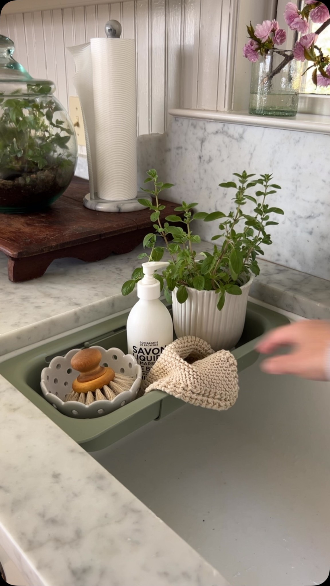 This $6 expandable sink colander is even better when you use it as a sink station, home base situation. 

I love using it to hold soaps, scrubbers, plants, the coffee spoon, my tiny watering can and more. 

Yes it’s a colander too but isn’t this an even better use?! 

My sink actually came with a metal colander as part of the workstation setup- it’s one of the things I get asked about most often. But you don’t need a new sink to be organized like this. 

In the video I show the colander both on the lower lip & top of my sink so you can see that it works both ways. 
