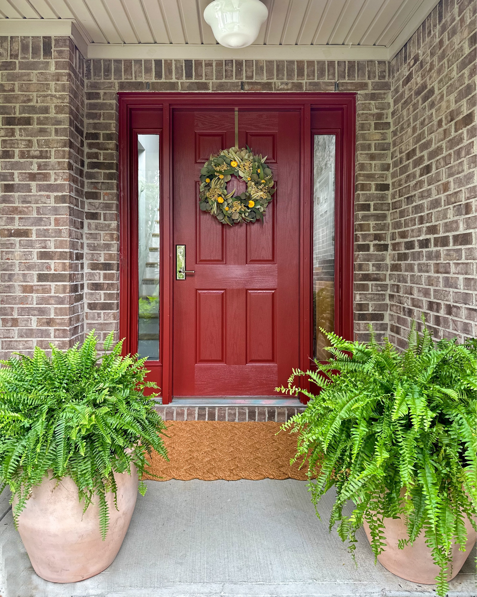 Front porch refresh - red front door, polished nickel door hardware, schoolhouse semi flush light, antique terracotta planters, woven doormat 

#LTKHome #LTKSummerSales #LTKSeasonal