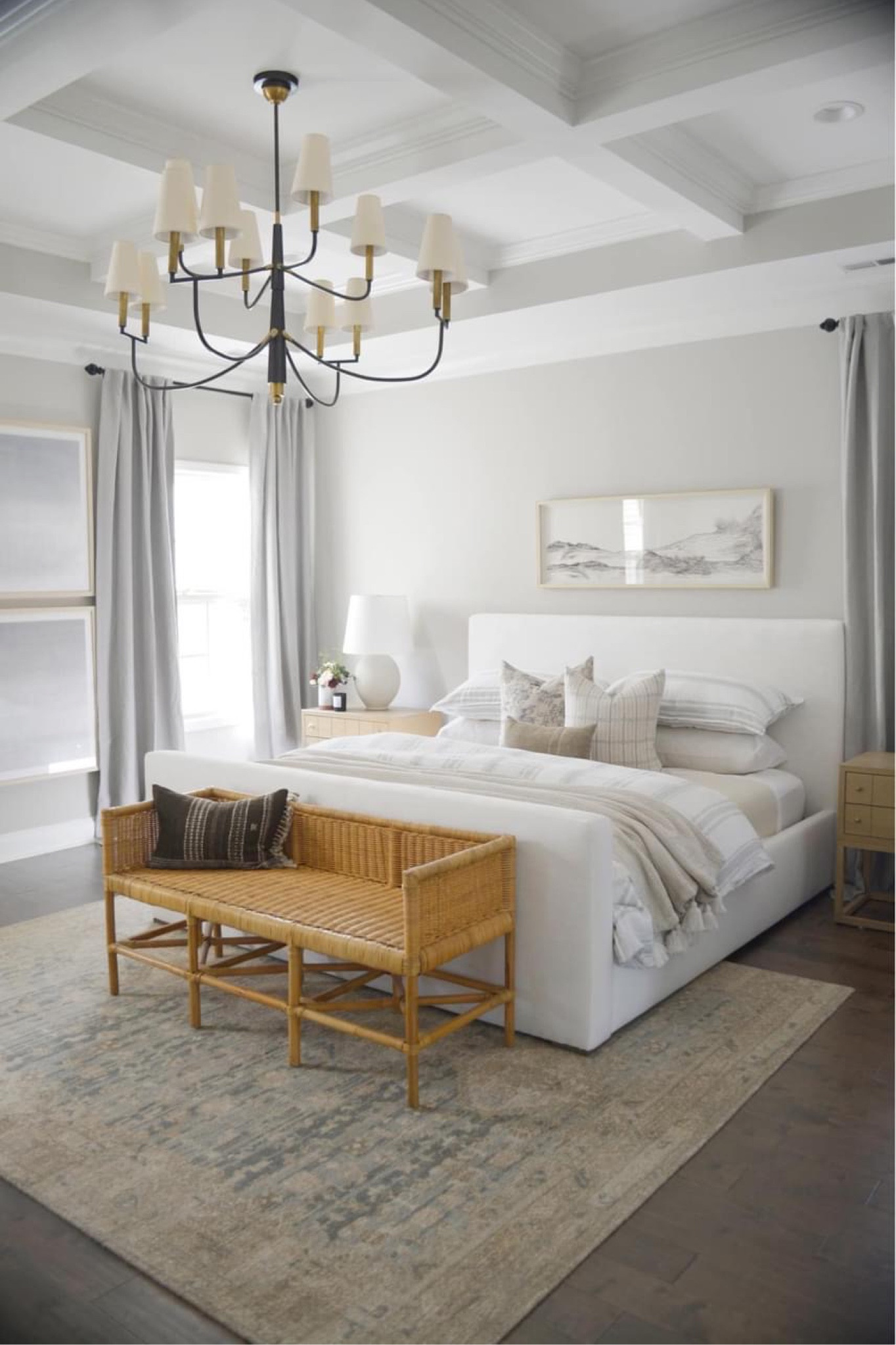 Primary bedroom- white upholstered bed, rattan bench, vintage rug, art above bed, chandelier in bedroom, target curtains, Roman shades 

#LTKsalealert #LTKhome #LTKFind