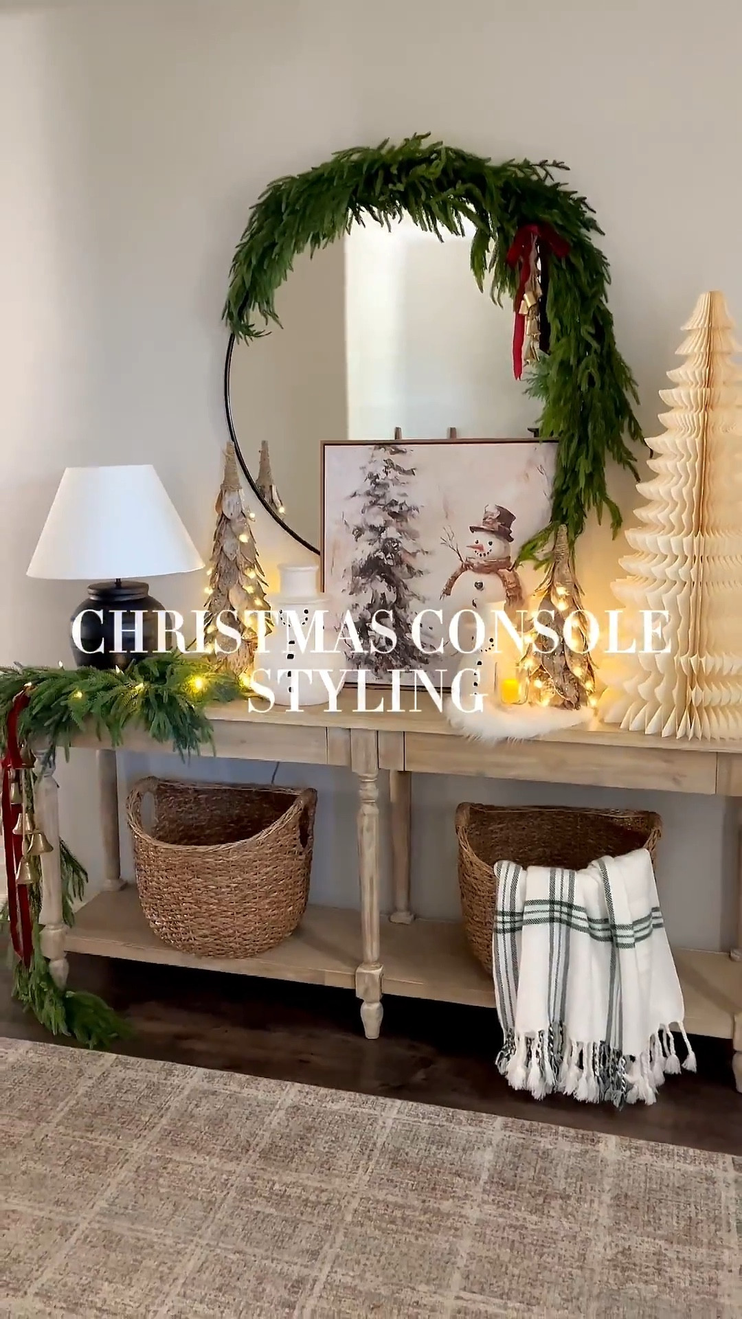 CHRISTMAS console styling!  Follow @lifeinmyarizonahome on Instagram for more holiday ideas and inspiration. 

I went for a fun whimsical look with this oversized paper tree and these adorable snowmen. I absolutely love these birch trees, that can be set on a timer, and this beautiful artwork helps complete the look!  

For reference:
Mirror garland used one 5ft Norfolk garland and 3 additional Norfolk stems. 
Artwork is in the 24x24 inch size.
The birch trees are the medium and small size. 
The table garland is a 6ft Norfolk garland with 3 additional Norfolk stems. 
The bells on the mirror are a simple DIY with 6 mini bells tied with jute string. 

#christmasdecor #homedecor #christmasstyling #consoletable #christmasentryway 

#LTKHoliday #LTKSeasonal #LTKHome