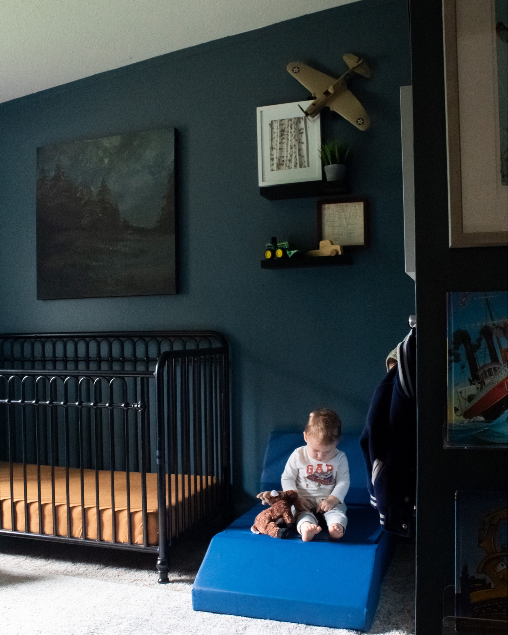 Moody navy blue boy nursery. Traditional nursery design. Black metal crib 

The painting above the crib was a DIY, linked some art with a similar vibe
Wall color is SW Rain Cloud

#LTKhome #LTKkids #LTKbaby