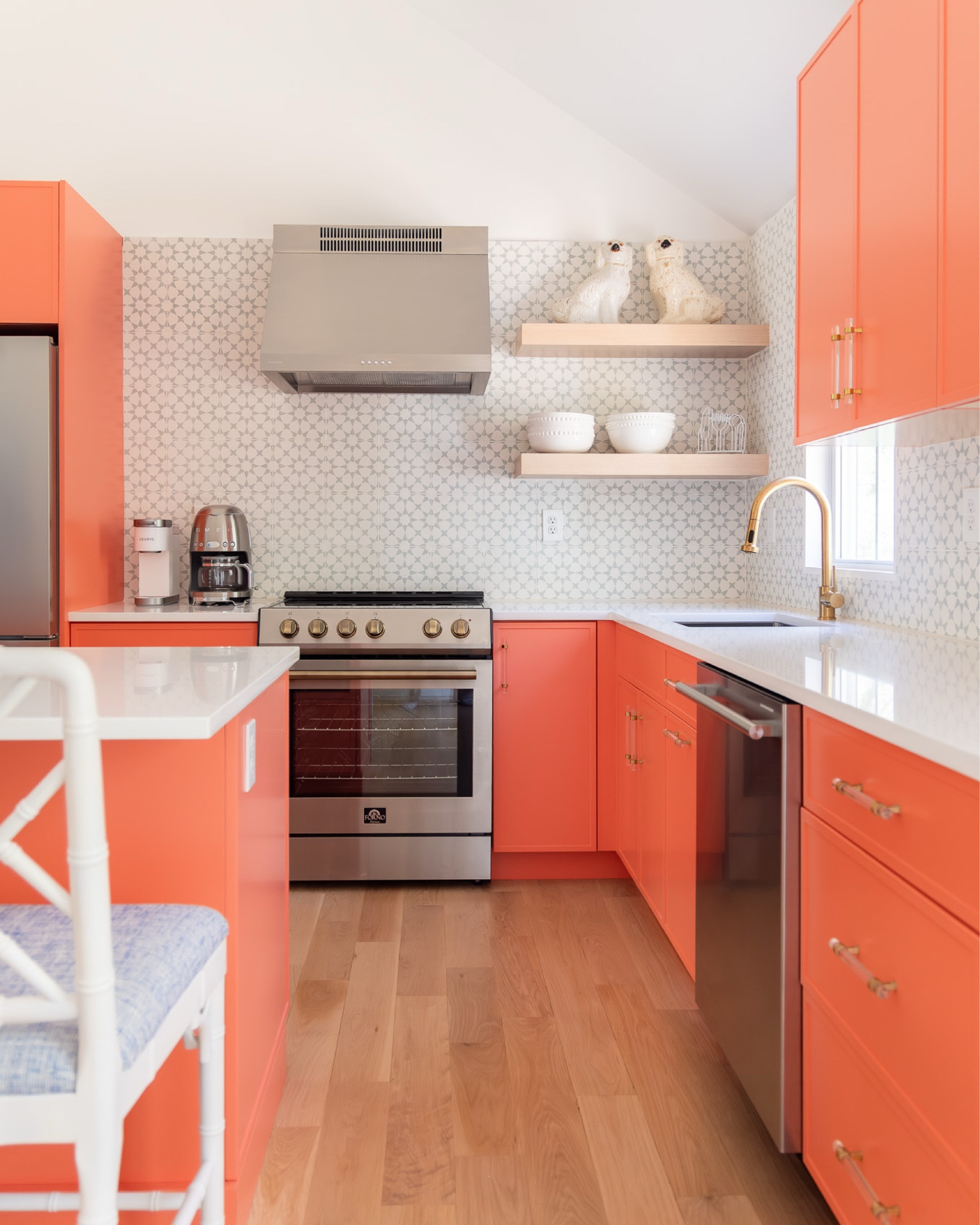 the kitchen turned out to be the most dramatic transformation at the #preppyhollowhouse. first, we removed the wall between the kitchen and living room to create one large open-concept space, then we vaulted the ceiling in the kitchen area to create symmetry and add volume. the existing kitchen felt dark and dated, so we introduced lots of color, using bright coral cabinets and a green star-patterned cement tile for the backsplash. we also added an island with additional storage and space for dining, as well as some white oak open shelving. #dwelloctoberstay #dwelloctober

#LTKHome