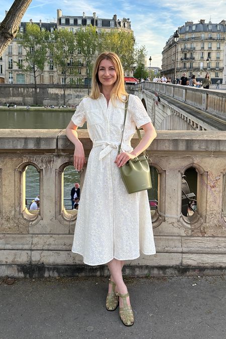 Parisian chic outfit for the warmer weather: white cotton dress with embroidery (a wardrobe staple) paired with a fun green leather bucket bag and green sandals 