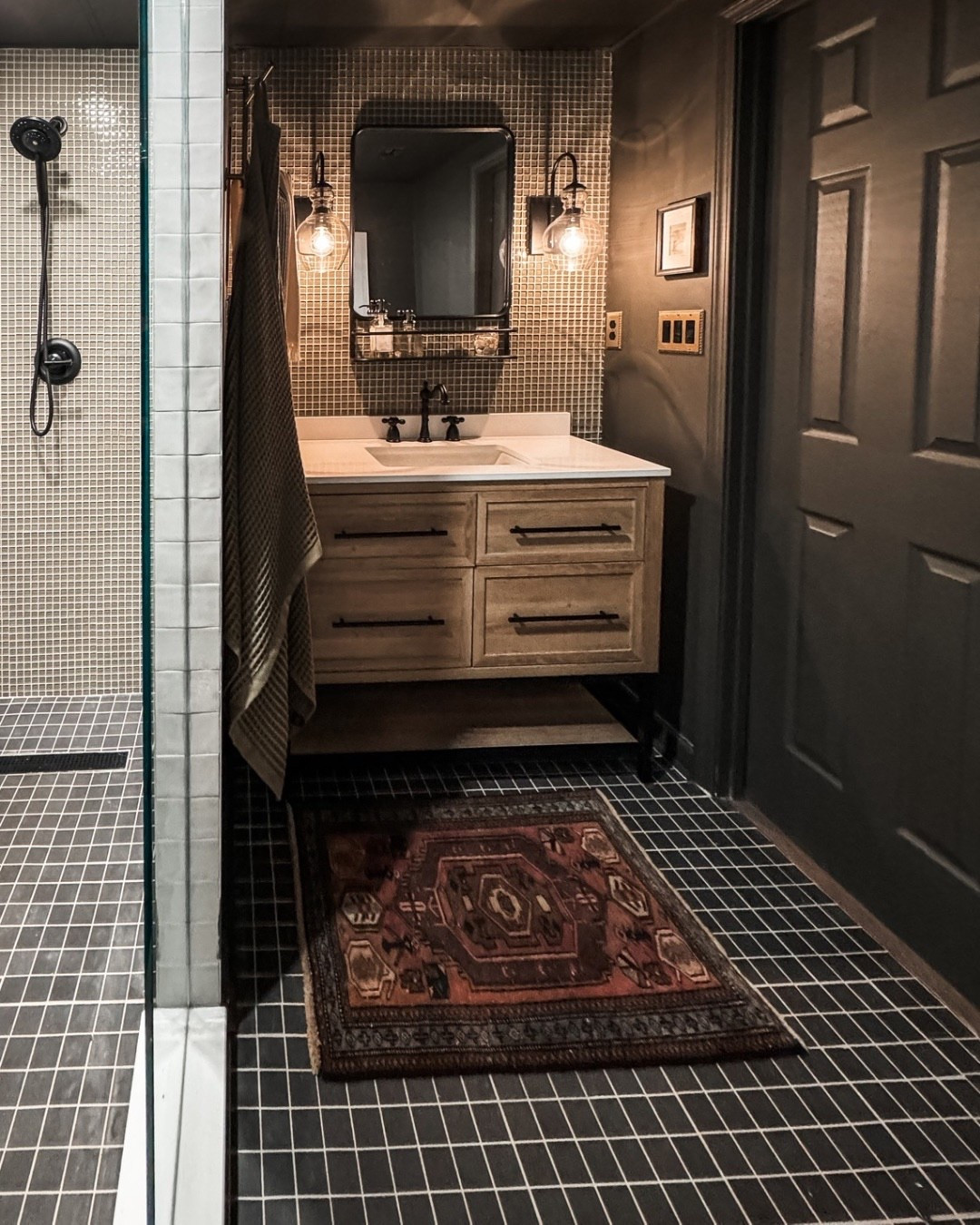 Moody bathroom goals ✨ This bathroom vanity moment brings together a floating wood vanity, black hardware, white quartz countertop, and a rectangular undermount sink for a clean but dramatic look. Loving the contrast of black mosaic tile flooring, textured wall tile, vintage-style rug, and black wall sconces that add warmth and character. A perfect mix of modern bathroom design and timeless finishes.

#eanesinteriors #bathroomvanity #bathroomdesign #floatingvanity #modernbathroom #blackhardware #mosaictiles #bathroomlighting #wallmountedvanity #bathroominspo #interiordetails #homeinspo

#LTKSeasonal #LTKOver40 #LTKHome