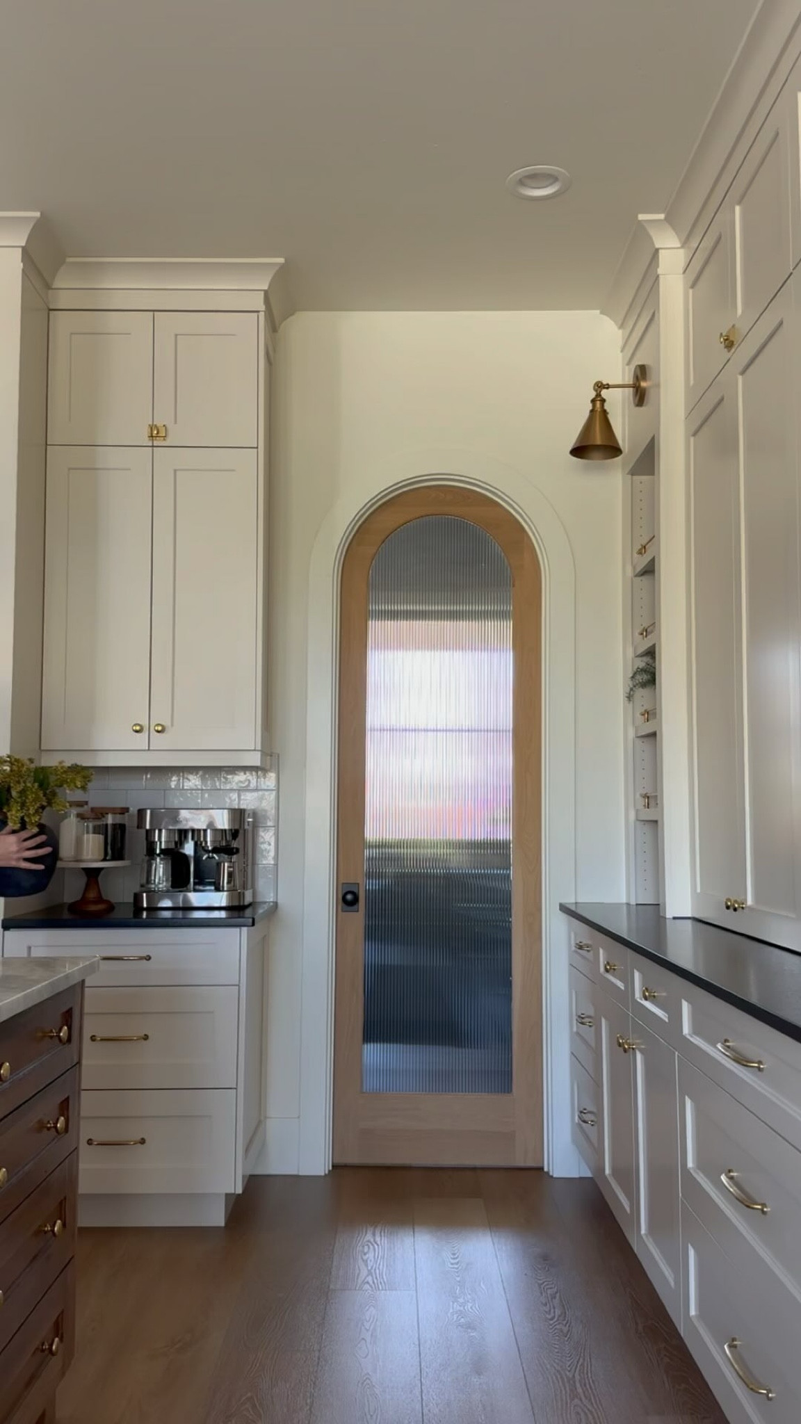 Hey there!! I am spilling the details about my kitchen today, answering the questions that I get in my DMs! 
✨make sure to SAVE this post to refer back to or SHARE with someone who may love it!

These are some of my most commonly asked questions, but if I missed something, feel free to reach out! 
Why do I share?? Because I spent hours and hours researching, and if I can save you some time, that’s what friends do 🤍
✨I always recommend testing paint colors in your space. The colors I had saved that I thought were sure things did NOT work in my actual home and I had to go back to the drawing board. Test on different walls, and check them at different times of day. ✨

Cabinets - Benjamin Moore Ballet White
Walls/Ceiling/Trim - Benjamin Moore White Dove 
Island - custom stain on White Oak
Ceilings - 10ft
Cabinet Style - Full European Overlay 
Hardware - @rejuvenation Aged Brass
Countertops - Honed Shadow Storm Marble and Leathered Absolute Black Granite 
Floors - Paradigm Conquest Citadel
Appliances - @thermadorhome panel ready fridge/freezer and @kitchenaidusa panel ready dishwashers
Range - 48” Ilve Nostalgie in Matte Graphite with Brass Knobs @ilve_usa 
Backsplash - @bedrosianstile 5x5 Cloe in White with warm grey grout 
Pendants - @hudsonvalleylighting 
**Pantry door is a custom design and build** BUT stay tuned for a fun update on this 👏🏻

Comment SHOP and I’ll send you all the links to my kitchen! 

#kitchendesign #kitchenrenovation #kitchencountertops #modernclassic #interiordesign #marblecountertops #granitecountertops