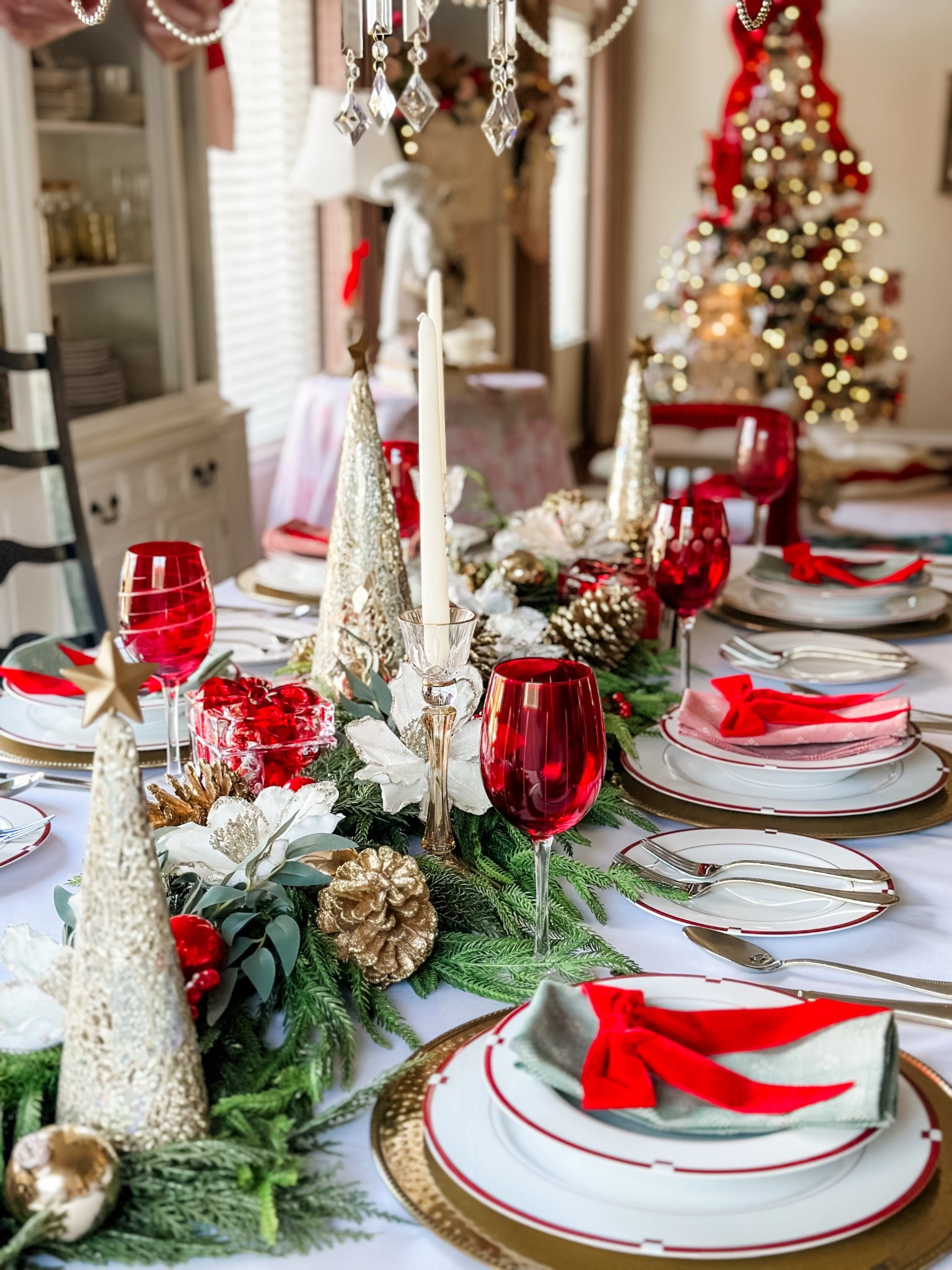 Classic Christmas Tablescape in gorgeous reds, whites, and green! 🎄

Gold holiday trees 
Christmas bows
Classic Christmas 
Holiday garland 
Holiday decorations 
Christmas ornaments 
Mikasa dinnerware 
Mikasa silverware 
Elegant table setting 
Table linens 

#LTKSeasonal #LTKHoliday #LTKHome