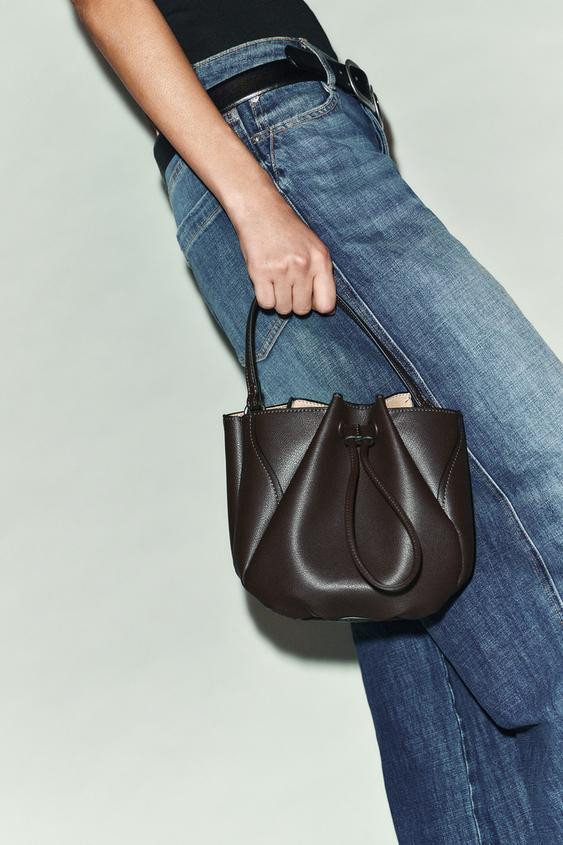 Mini bucket bag. Topstitching detail on the exterior. Interior zip compartment. Magnetic button c... | Zara US