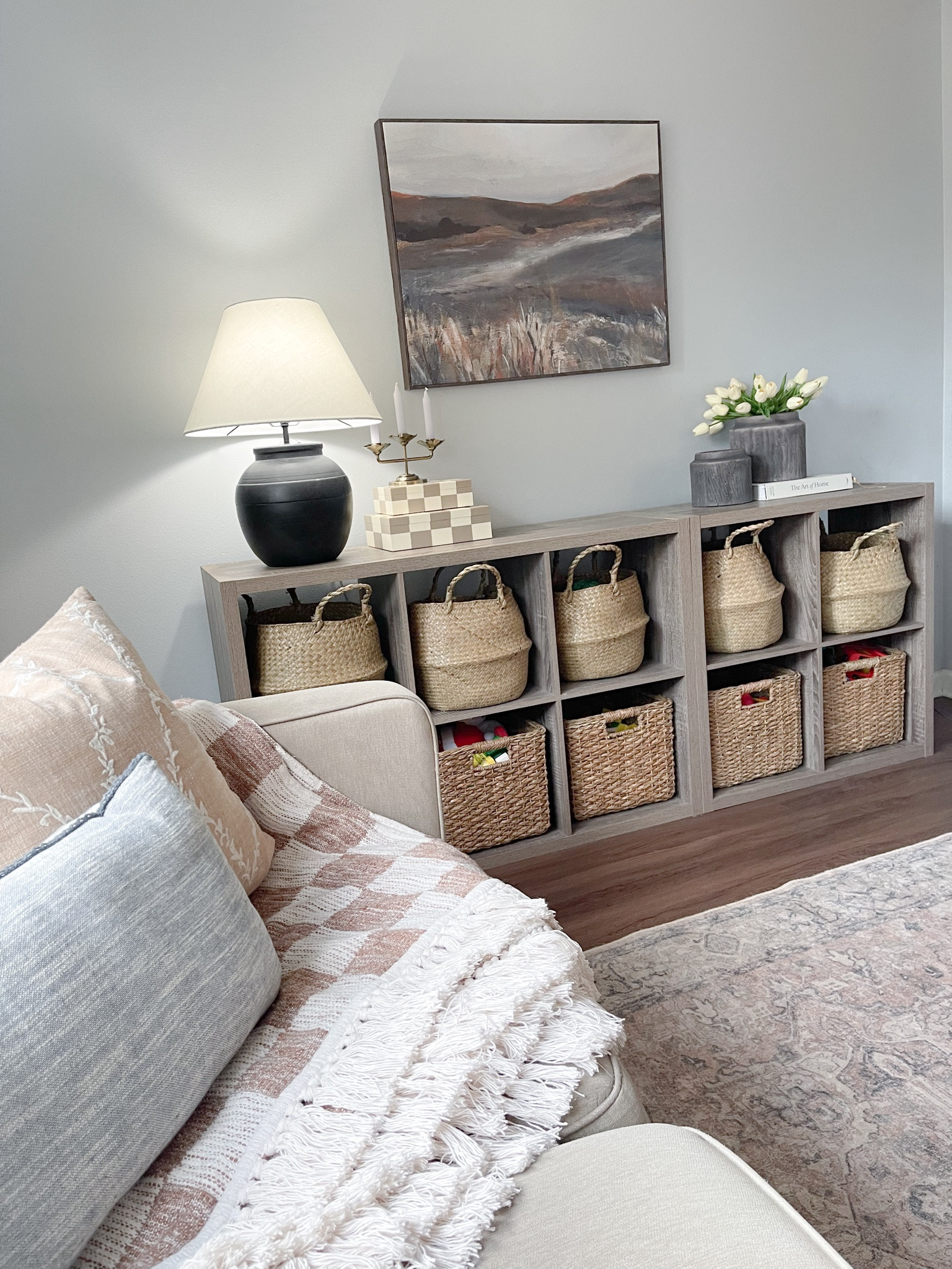 Playroom toy storage ideas. Cubed shelves. Wicker basket storage. Checkered boxes. Checkered blanket. Large wall art. Black table lamp. Walmart viral planters. White tulips. Faux florals. Home inspo. Living room ideas. #LTKMostLoved 

#LTKkids #LTKfamily #LTKhome