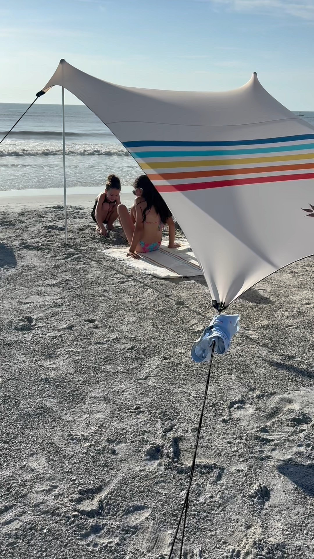Obsessed with the vintage style rainbow stripes on our beach tent. Quick and easy to put together. Just stretch it out (tighter than you think!) fill the bags with sand and prop up the two corners that give you the most shade! Sun changes location? So easy! Simply remove the two poles and place them on another side. 

#LTKTravel #LTKFamily #LTKSeasonal