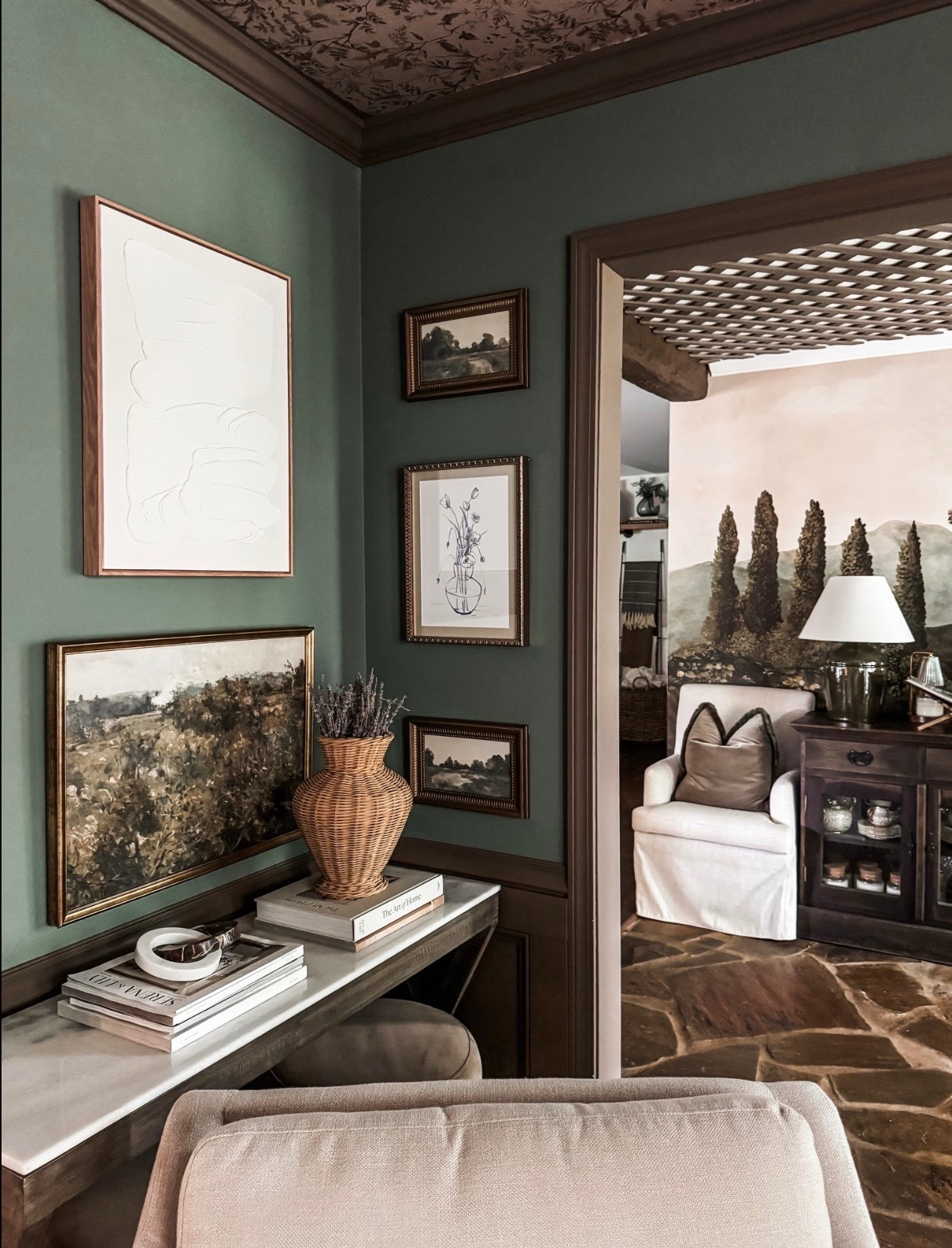 A cozy reading nook + gallery wall moment 🤍 This layered corner features green painted walls, vintage-style framed art, landscape artwork, and minimal line drawings for a timeless collected look. Styled with a woven wicker vase, ceramic decor, coffee table books, and a wood console table, this space blends classic home decor with warm neutrals and traditional interior design details that feel lived-in and intentional.

#eanesinteriors #gallerywall #classicinteriors #traditionaldecor #greenwalls #framedart #vintagestyle #wovenvase #homestyling #cozycorner #interiordetails #layereddecor #timelessdesign #ltkhome

#LTKOver40 #LTKSeasonal #LTKHome