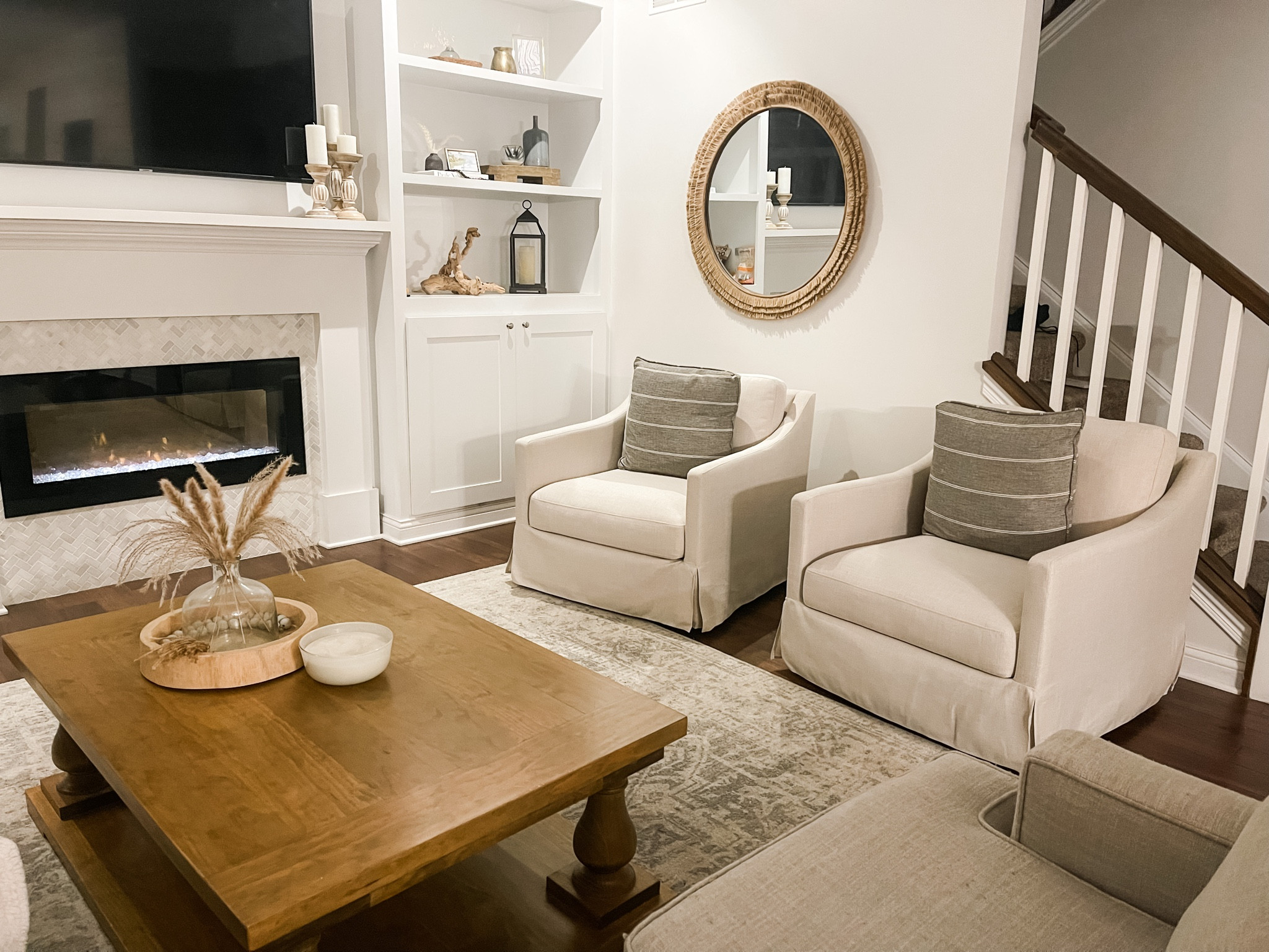 Target swivel arm chairs, round mirror, built-ins, neutral rug, wood coffee table, fireplace, white, table decor, tray, candle

#LTKhome #LTKFind