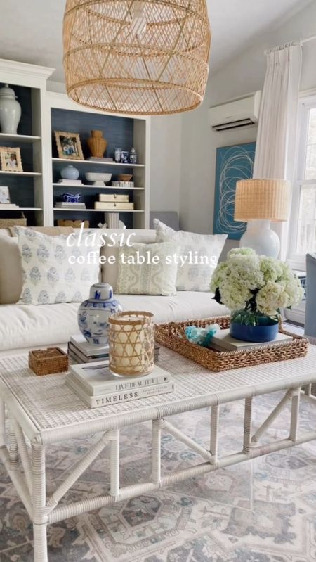 Classic coffee table styling, coffee, table, wicker, coffee, table, wicker, blue and white, ginger jar, vase, glass, hurricane, so far, throw pillows, pendant, rattan pendant 

#LTKhome
