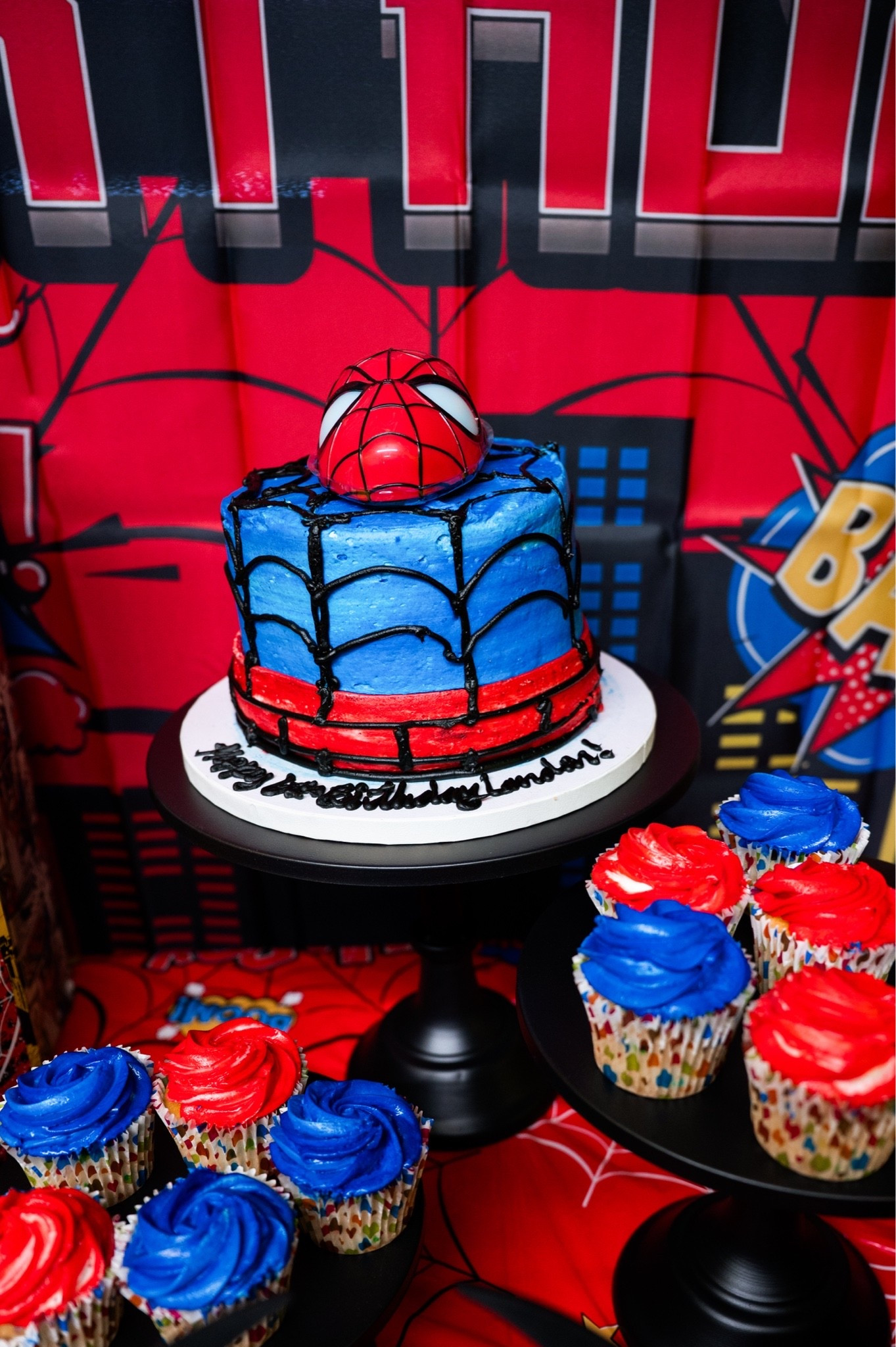 Spiderman cake topper and black cake and cupcake stands