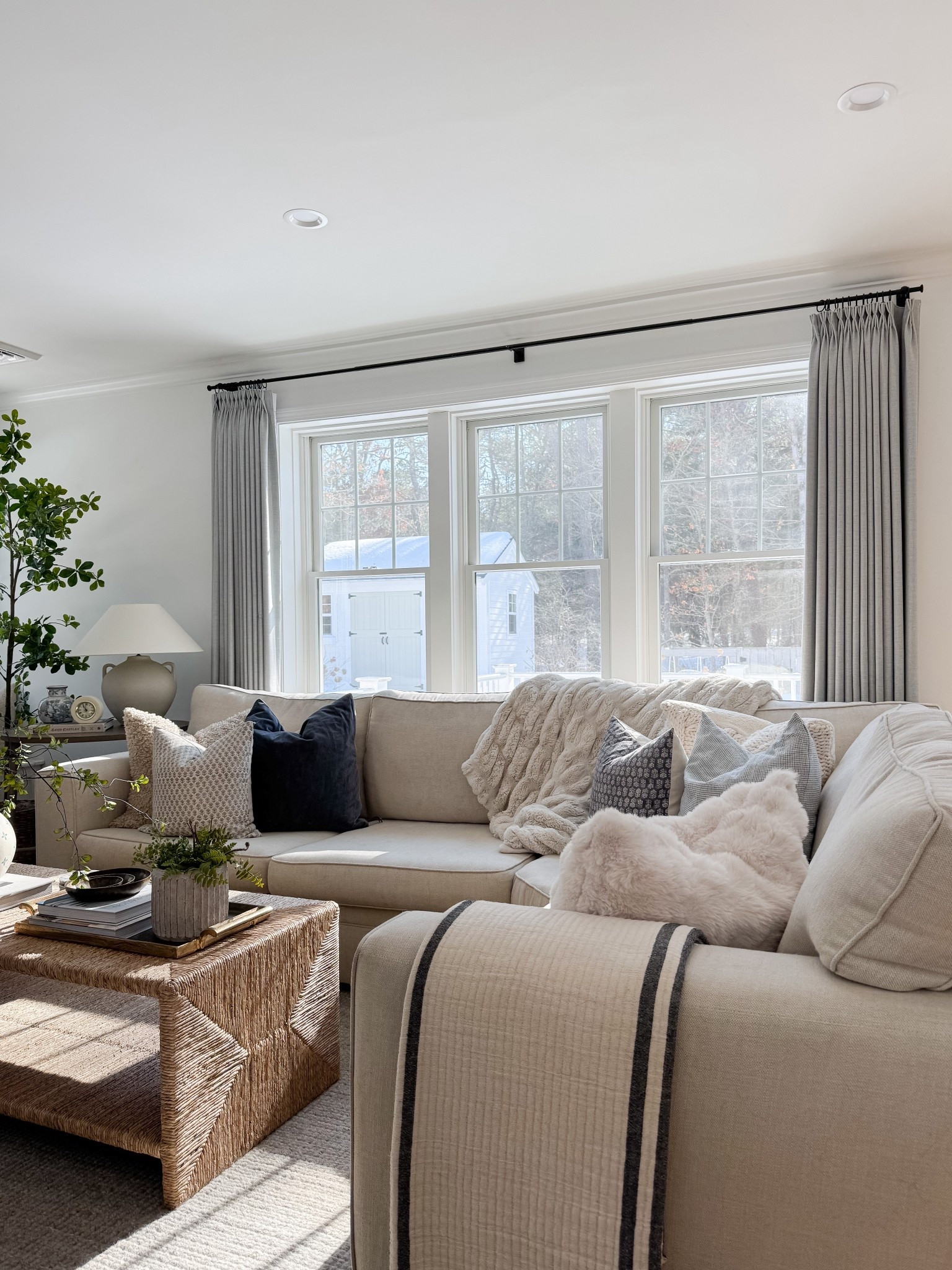 Bright neutral living room with woven coffee table, ceramic vase with greenery branches, linen drapery panels, and soft textured pillows. Natural light, organic materials, and warm wood tones bring a relaxed coastal feel. 
woven coffee table, neutral coastal decor, linen curtains, living room inspiration, spring home refresh, natural textures, ceramic vase decor, greenery stems, light filled living room, warm wood tones, coastal style, organic modern, sherri calnan home

#LTKHome