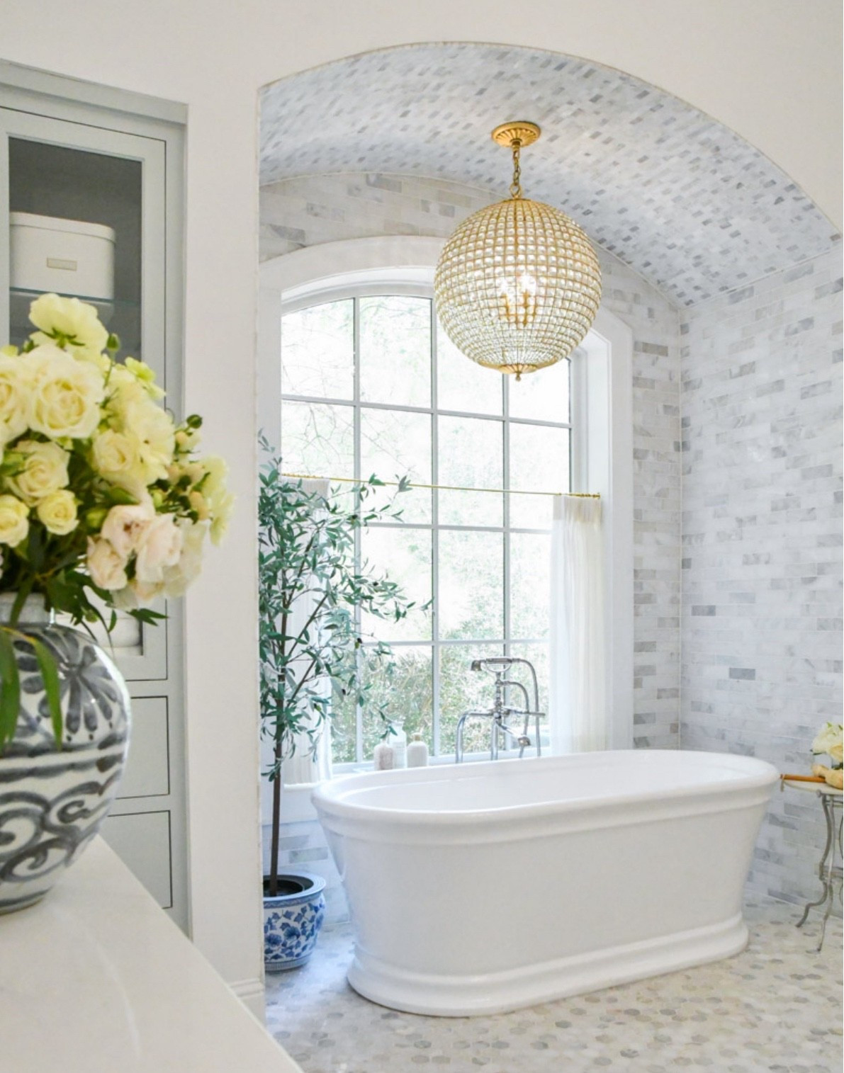 Primary bathroom chandelier
Blue and white vase
Olive tree, planter
Bathtub free-standing faucet 
