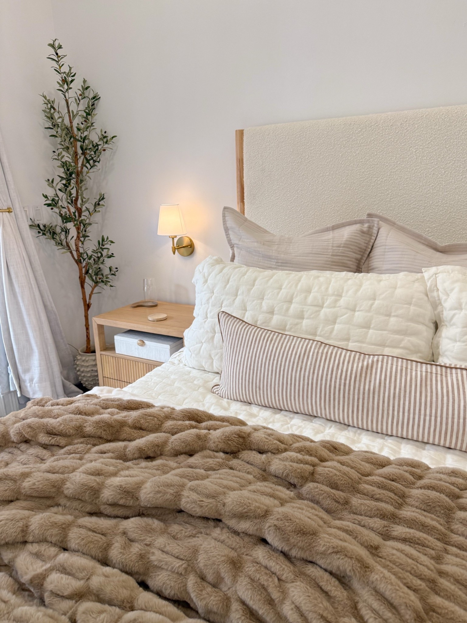 Bedroom refresh for fall! 🤎 love the beige and brown tones in the pillows and blanket! We just recently got these nightstands, boucle and wood bed frame and wireless sconces. Our bedroom feels so cozy and warm now!! 

Neutral home, Quince, amazon home finds, faux olive tree, Lola blanket, quilt, euro pillows, lumbar pillow, pillow inserts, comfymaxxing, curtains, wayfair furniture, birch lane, fancythingsblog

#LTKHome #LTKSeasonal #LTKmorningroutine