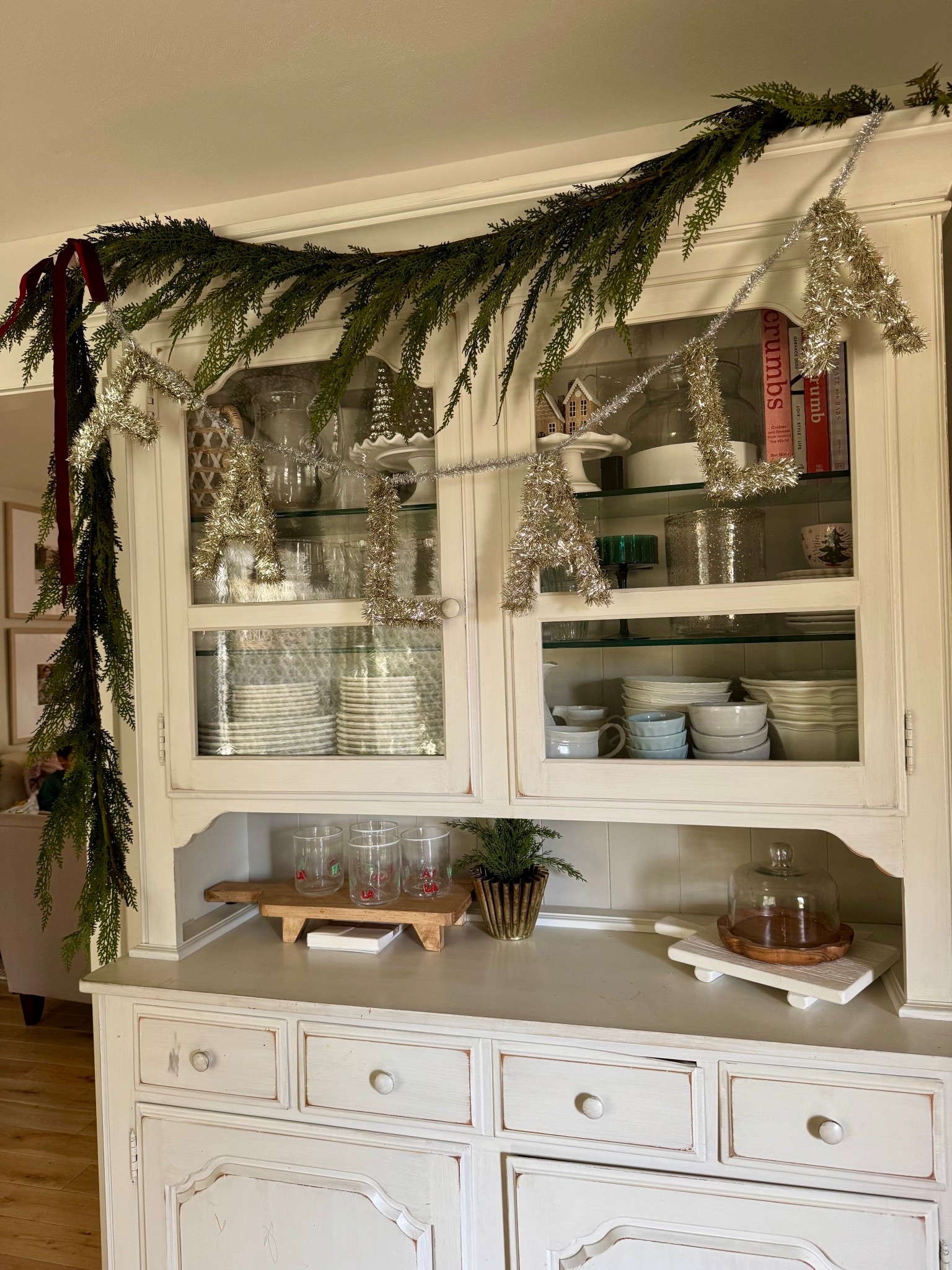Festive hutch all decorated for Christmas. I store all my nicer dishes here (that rarely get used) and my seasonal pretties. I just adore it with garland this year!!

Cedar garland
Hutch for the holidays 
Falala garland 